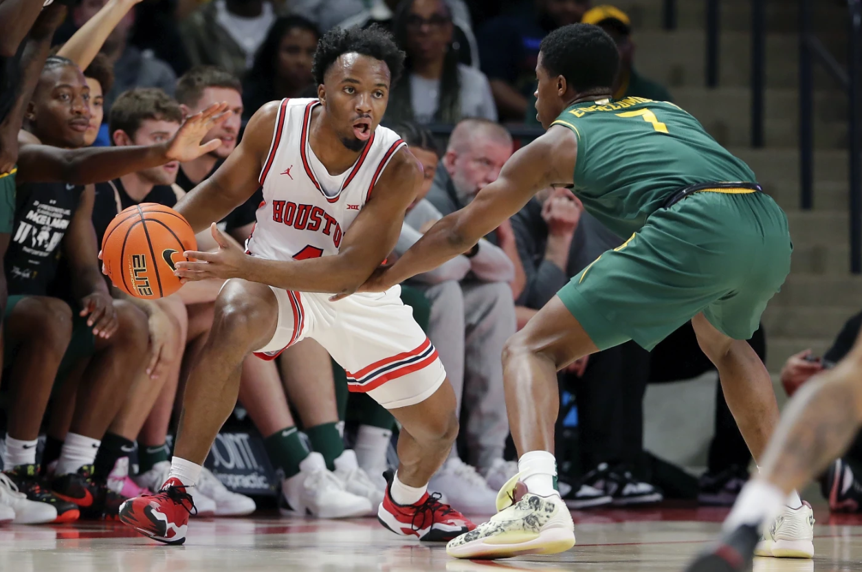 Houston guard L.J. Cryer, left, drives around Baylor guard V.J. Edgecombe during the first half of an NCAA basketball game Monday, Feb. 10, 2025 in Houston.