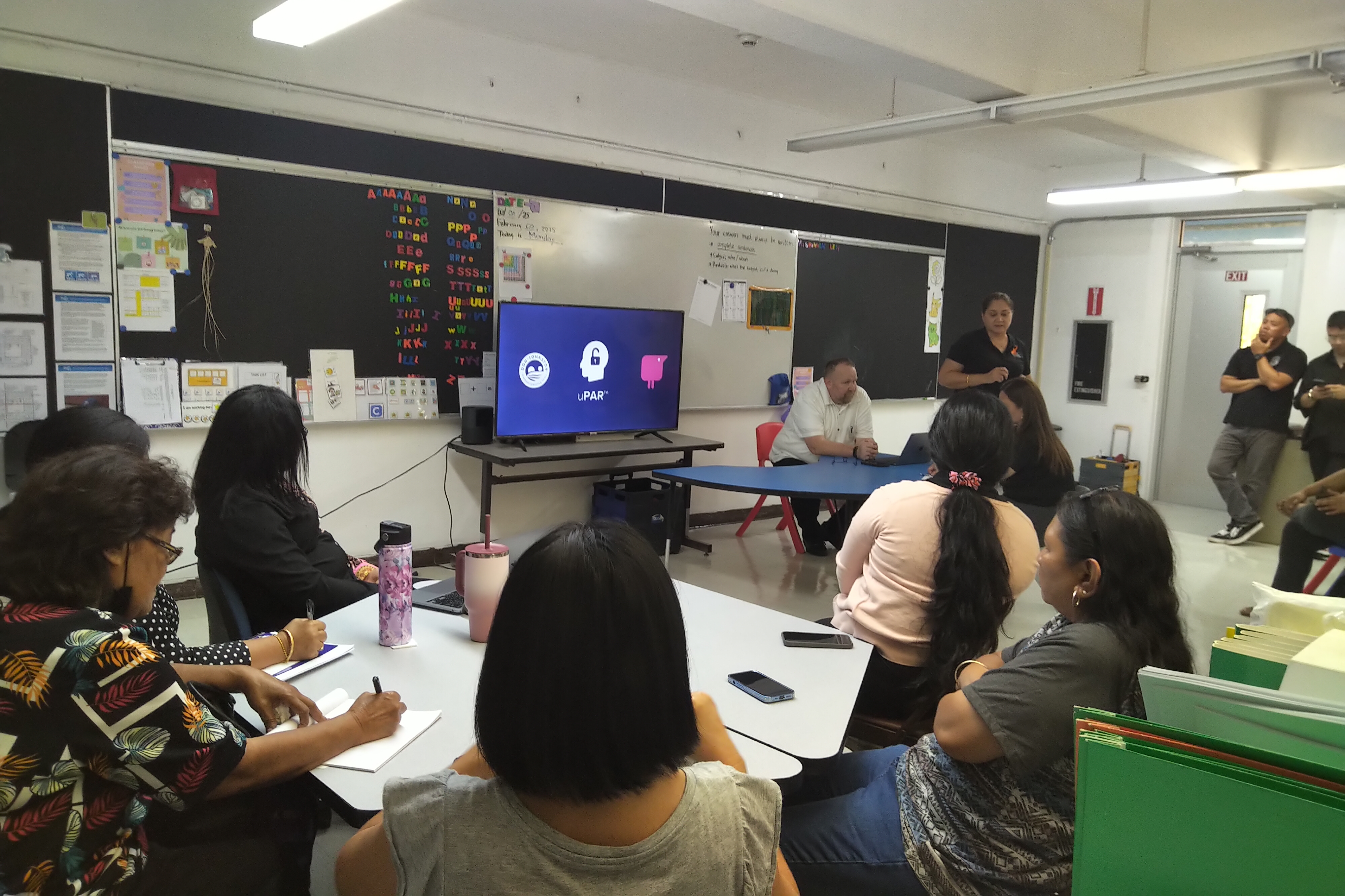 Special Education Program State Director Donna M. Flores introduces Dave Butler, the national account director for Everway, seated, background, who facilitated in-person sessions on the use of the reading tool on Feb. 3 and 4 at Garapan and Sinapalo elementary schools.