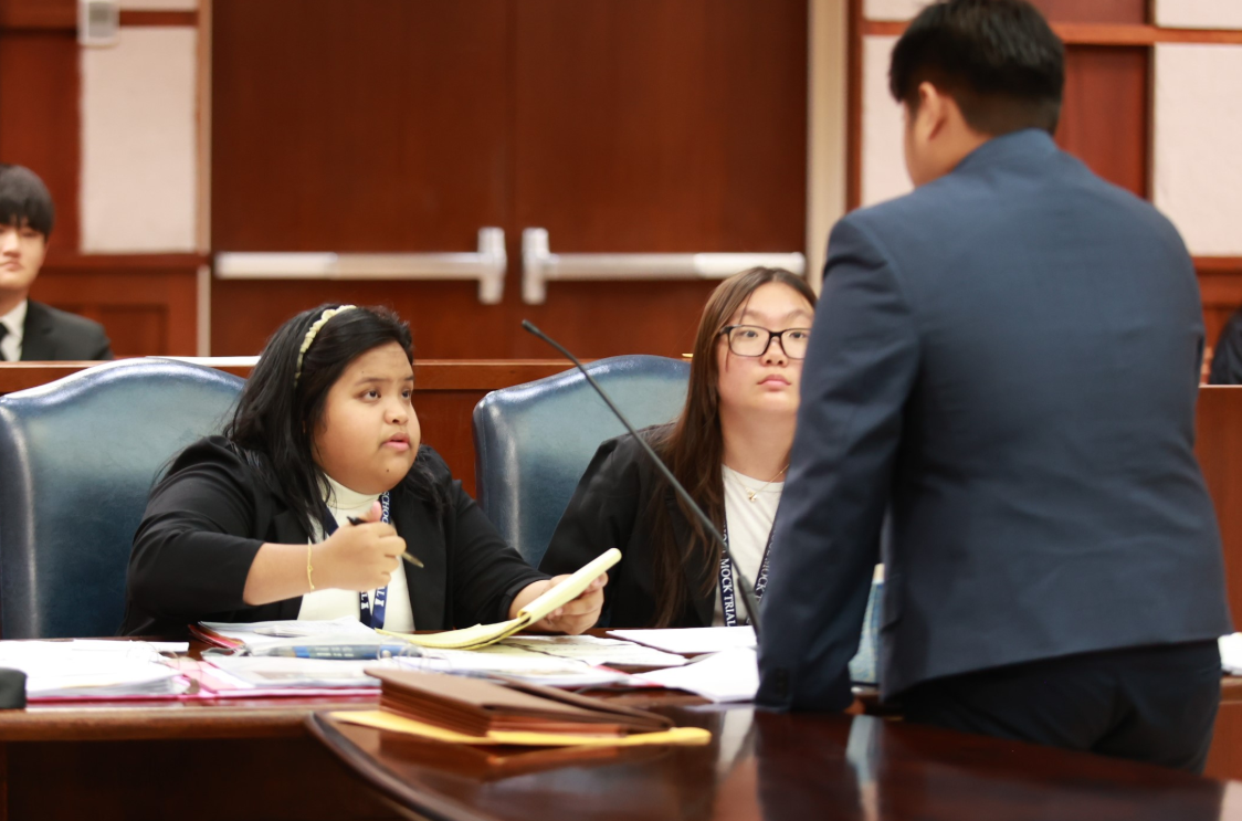 Tinian High School competitor Ainsley P. Ancheta discusses strategy with her fellow attorneys during Preliminary Round 2.Contributed photo