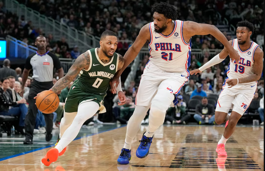 Milwaukee Bucks guard Damian Lillard (0) drives for the basket against Philadelphia 76ers center Joel Embiid (21) during the third quarter at Fiserv Forum in Milwaukee, Wisconsin, Feb. 9, 2025.