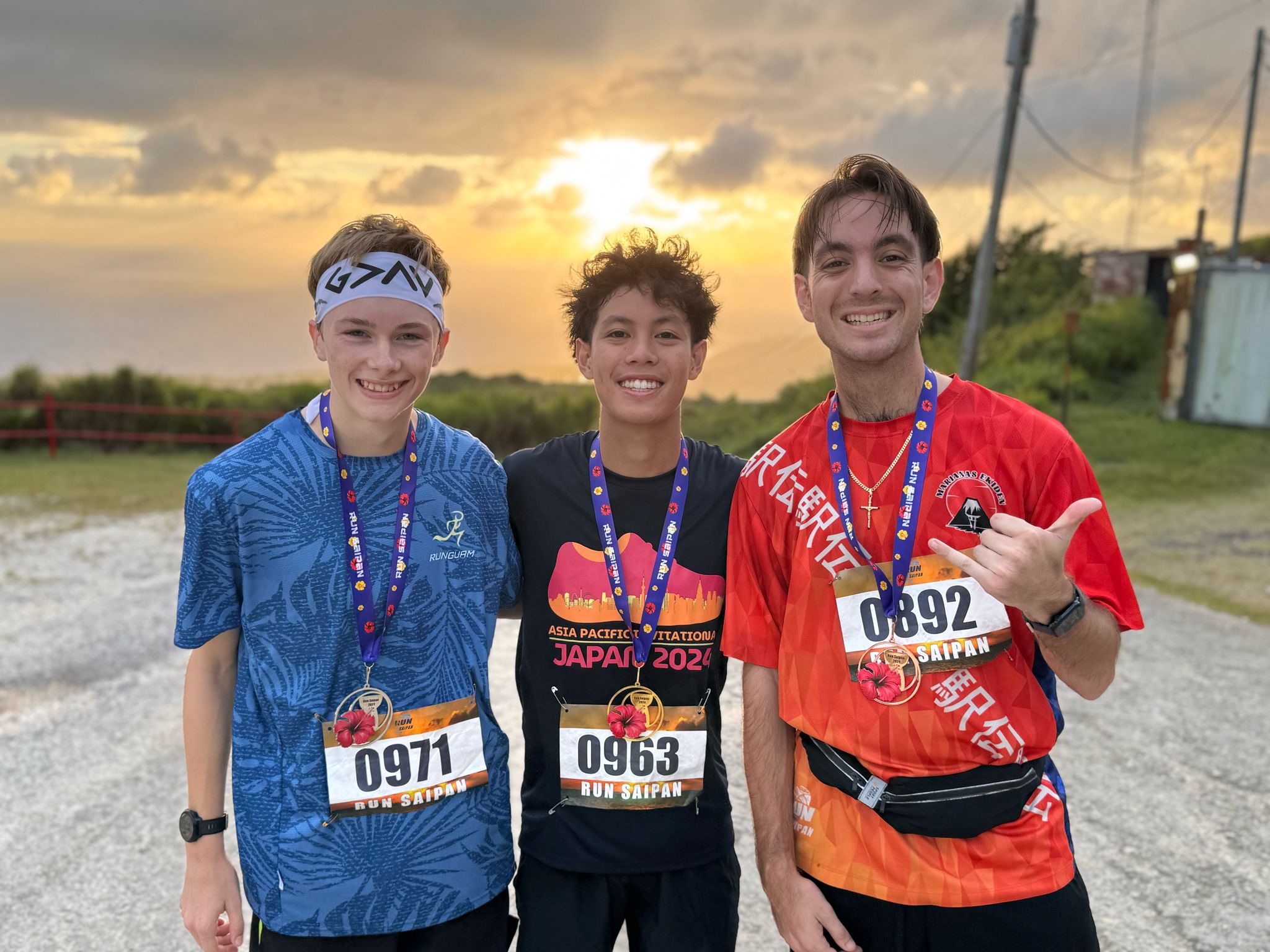 The top 3 men runners Landen Taflinger, Victor Nash Santos, and Jordan Ruiz pose for a photo on Mount Tapochao.