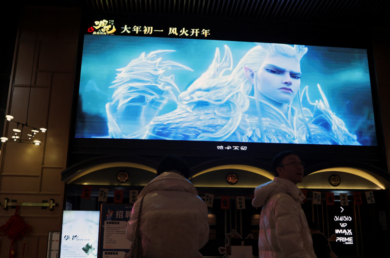 People stand near a giant screen showing a trailer for the Chinese movie Nezha 2, at a cinema in Beijing, China, Feb. 6, 2025.