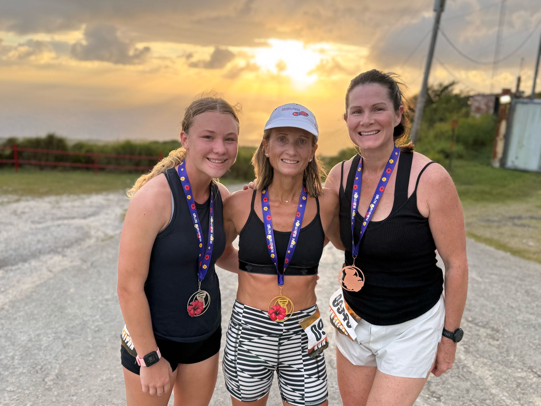 Top 3 women runners Addalee Taflinger, Krista Hawley, and Terra Allen pose for a photo on Mount Tapochao.
