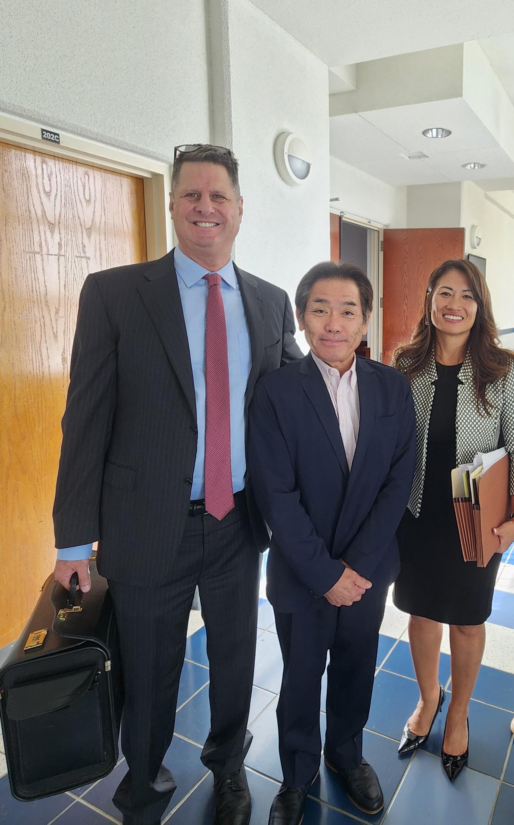 Attorneys Colin Thompson, left, and Janet King, right, with their client Hideaki Sawada pose for Variety at the local courthouse on Friday.