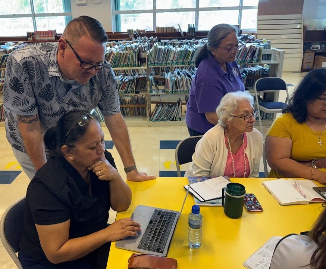 School principals Derwin John, Annette Calvo, and Daisy Quitugua, partly hidden, with University of Guam-CEDDERS’ Jun De Leon at Sinapalo Elementary on Rota.