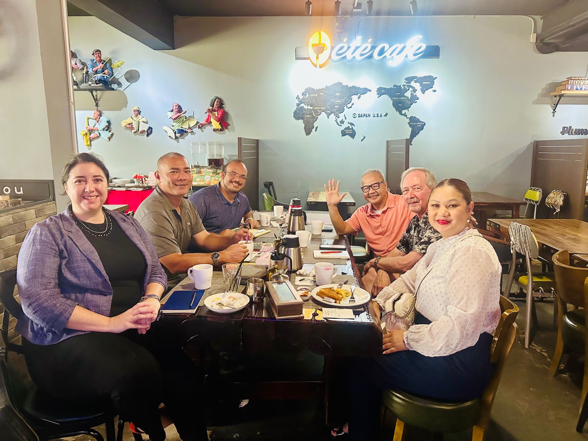 Sen. Corina Magofna with Economic Recovery Corps fellow Carina Pinales, who works with the Department of Commerce, pose for a photo with officials of the Kagman Agricultural Farms and Producers Association at Ete Café in Garapan last week. Contributed photo