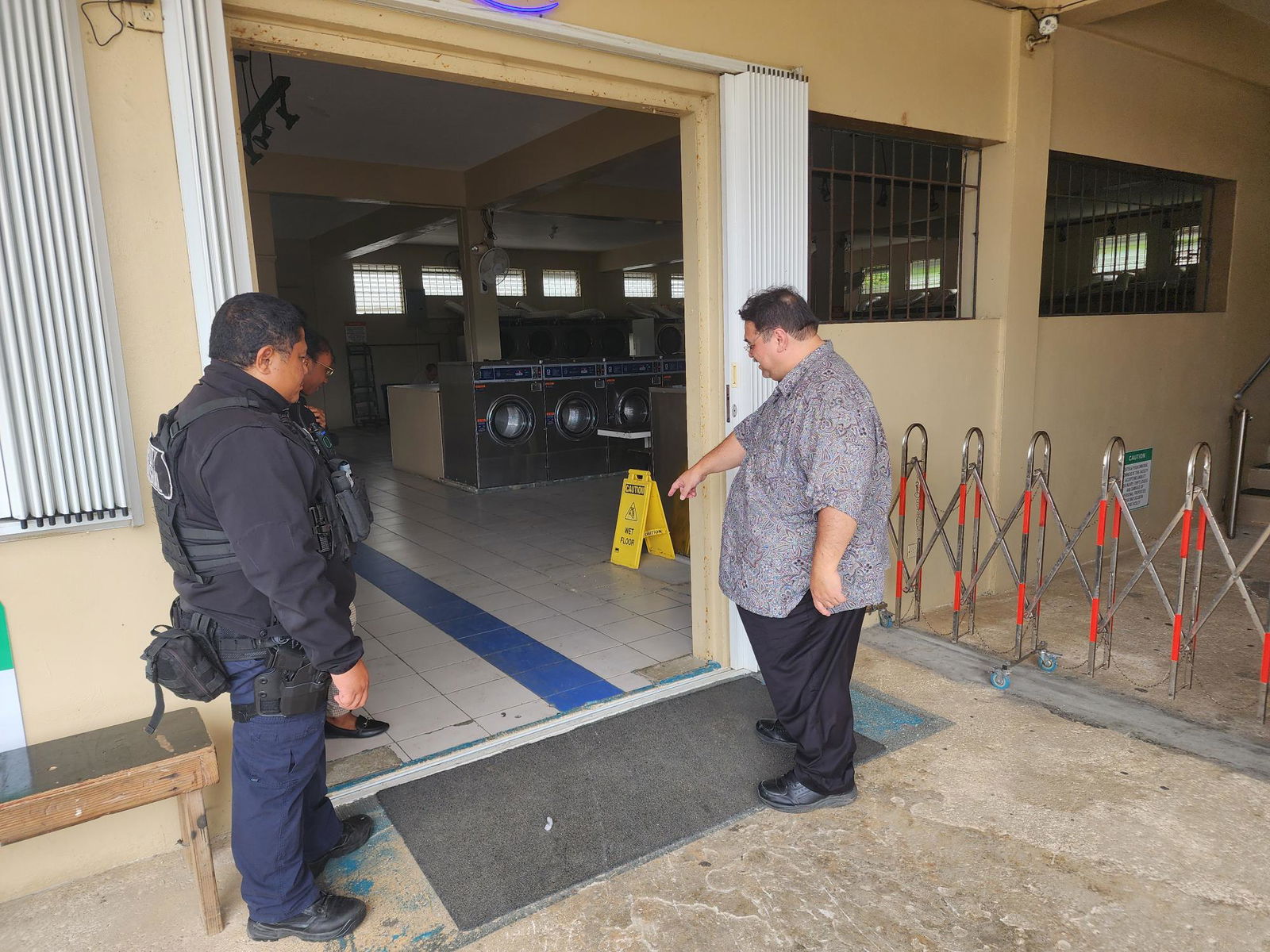 Judge Joseph N. Camacho points to a spot at the entrance of Cool Laundry in Kagman. On Wednesday afternoon. Accompanying him is a CNMI Marshal.