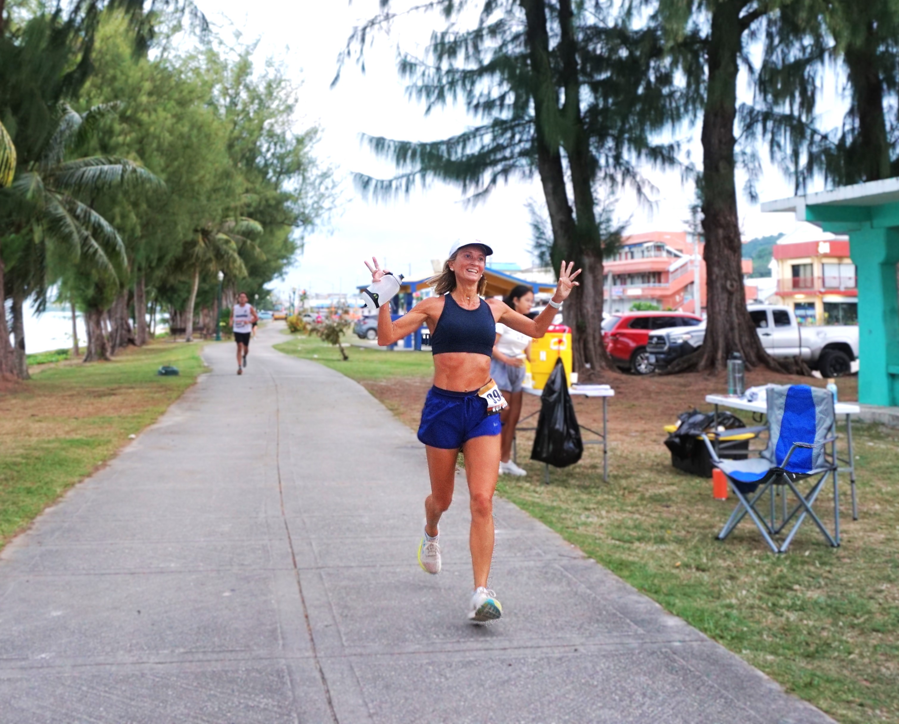 Krista Hawley celebrates as she approaches the finish line of Run Saipan’s Trinity 2025/Beach Path 10K near Oleai Beach Bar & Grill on Saturday.