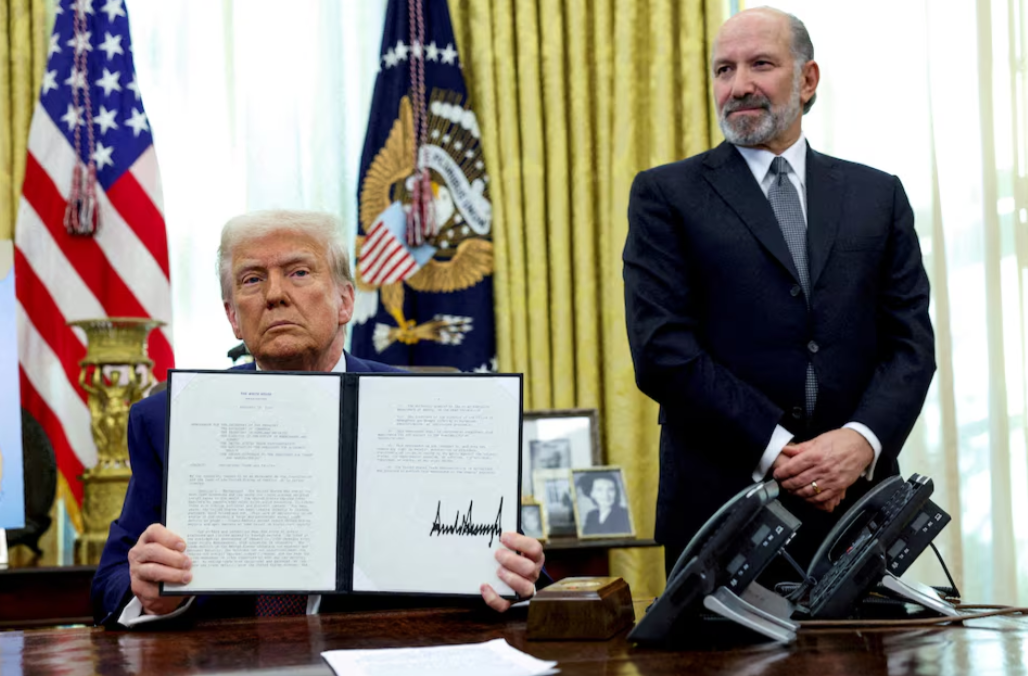 President Donald Trump holds an executive order about tariffs increase, flanked by U.S. Commerce Secretary Howard Lutnick, in the Oval Office of the White House in Washington, D.C., Feb. 13, 2025.REUTERS