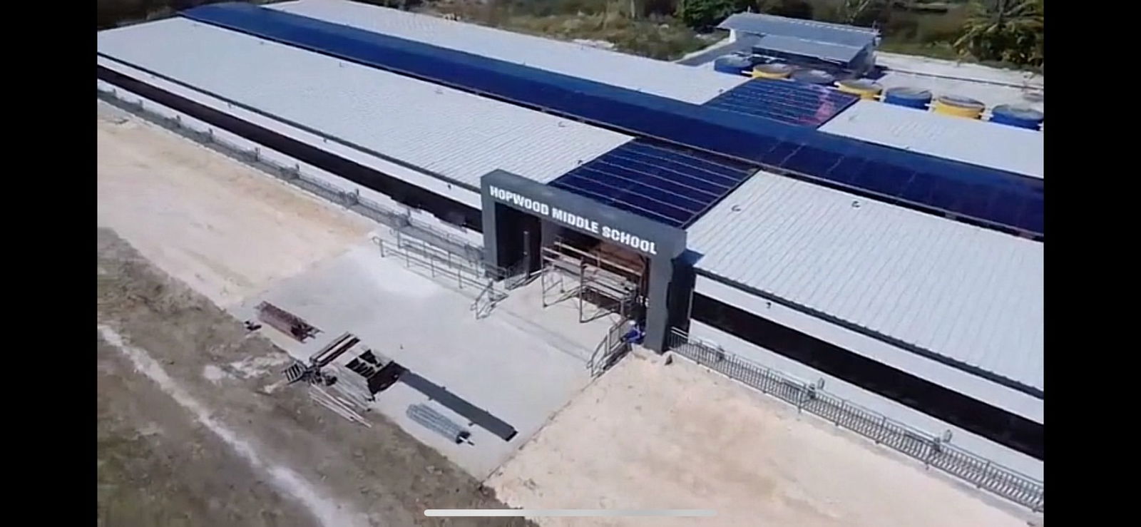 Solar panels serve as a canopy over the modular school building’s hallway.