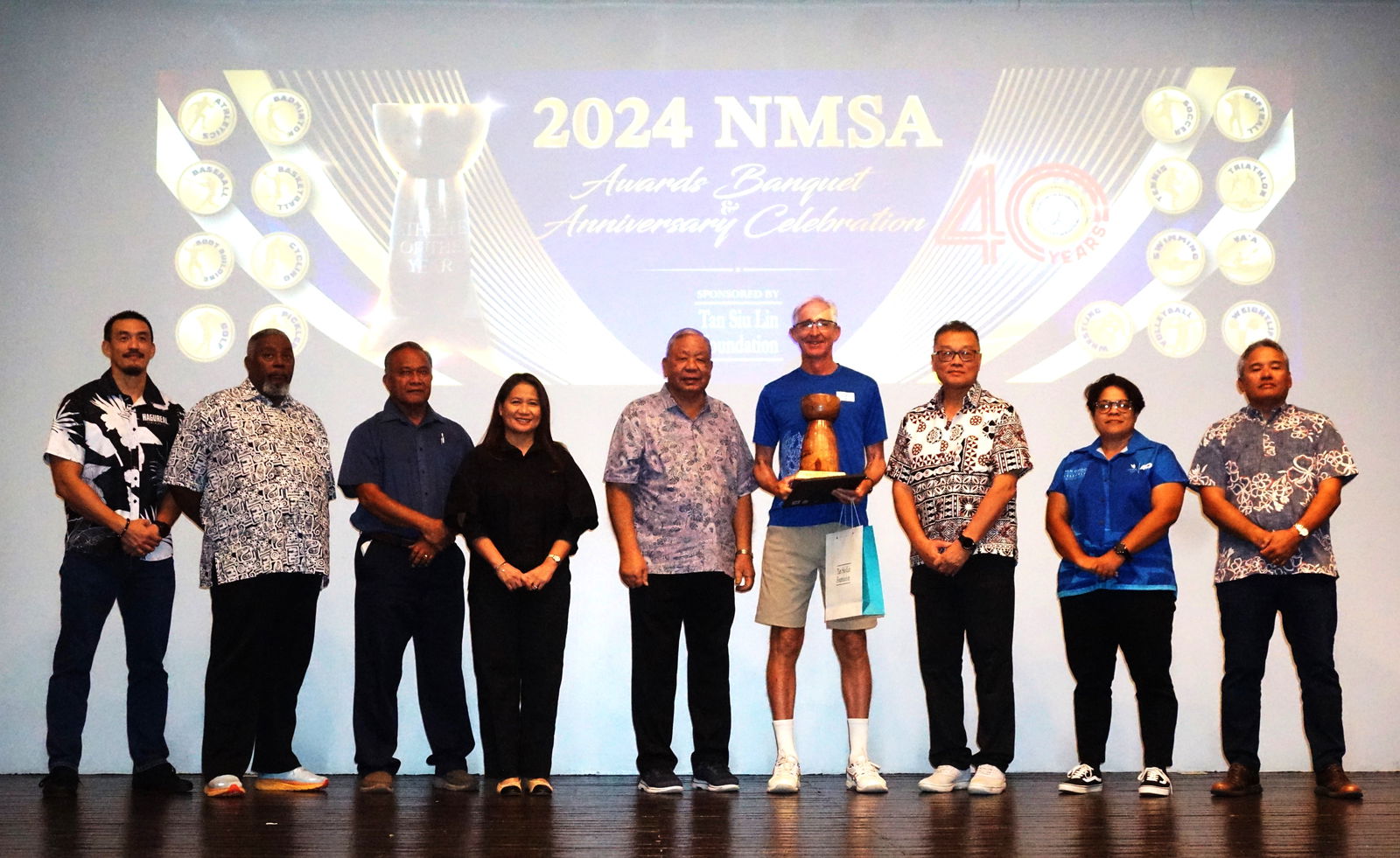 Jeff Race poses with the Coach of the Year Award alongside Lt. Gov David Apatang and the Northern Marianas Sports Association board members during the NMSA annual awards banquet and 40th anniversary celebration at the Taga Hall of Crowne Plaza Resort Saipan on Thursday.Photos by James F. Sablan Jr.