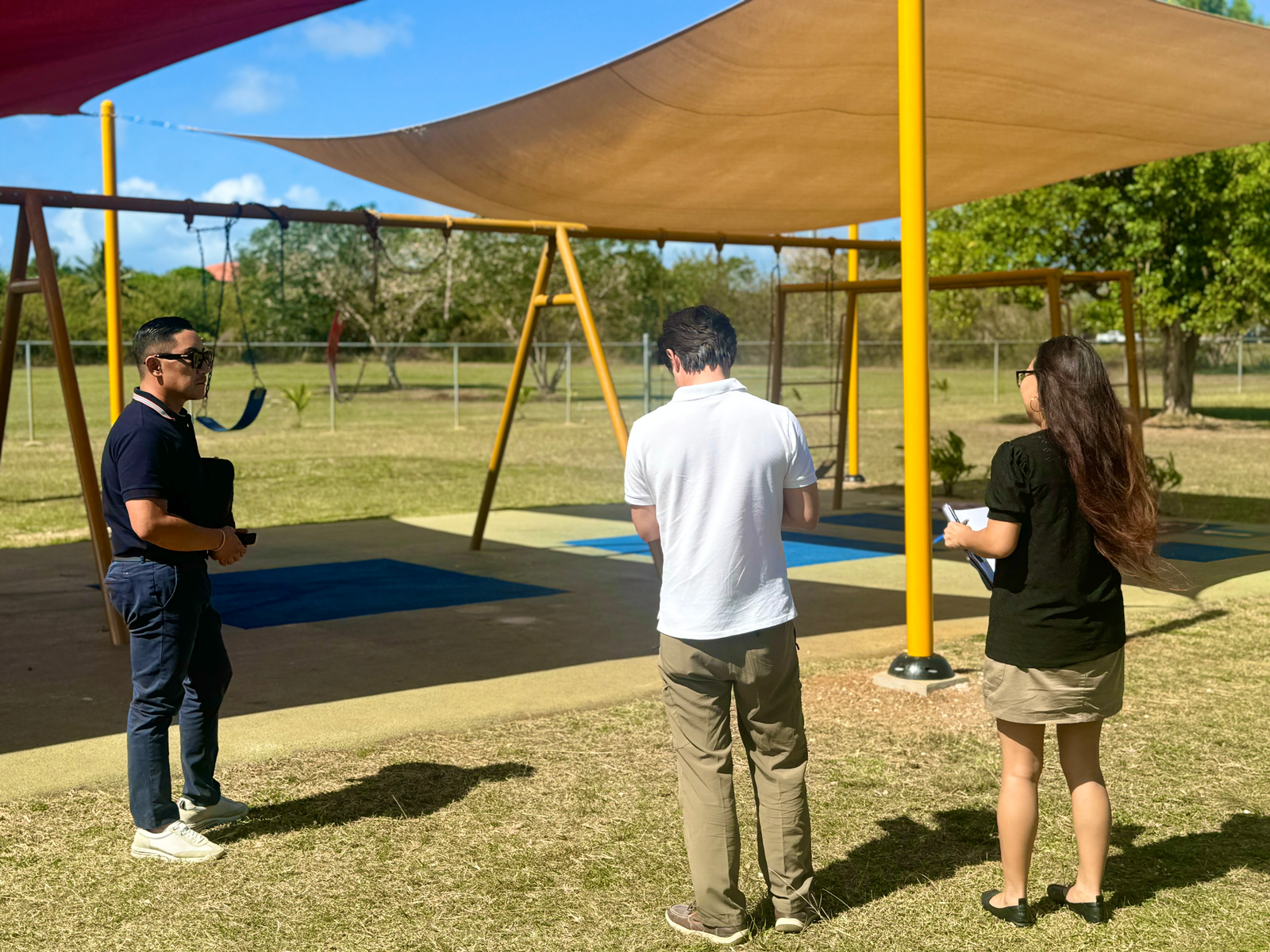 Koblerville Elementary School Principal Naomi Nishimura with CJ Innovation Co. CEO Hwang Hee Jung and Director Kim Jung Hoon in a designated installation area near the school playground, where new tire structures will be placed.