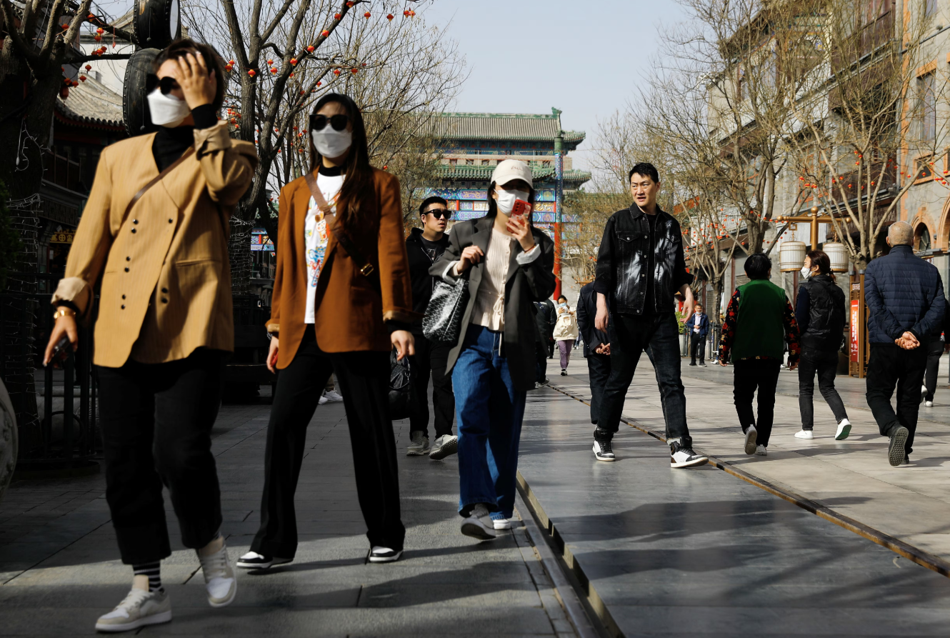 People walk at the tourism site of Qianmen street, in Beijing, China on March 14, 2023.REUTERS