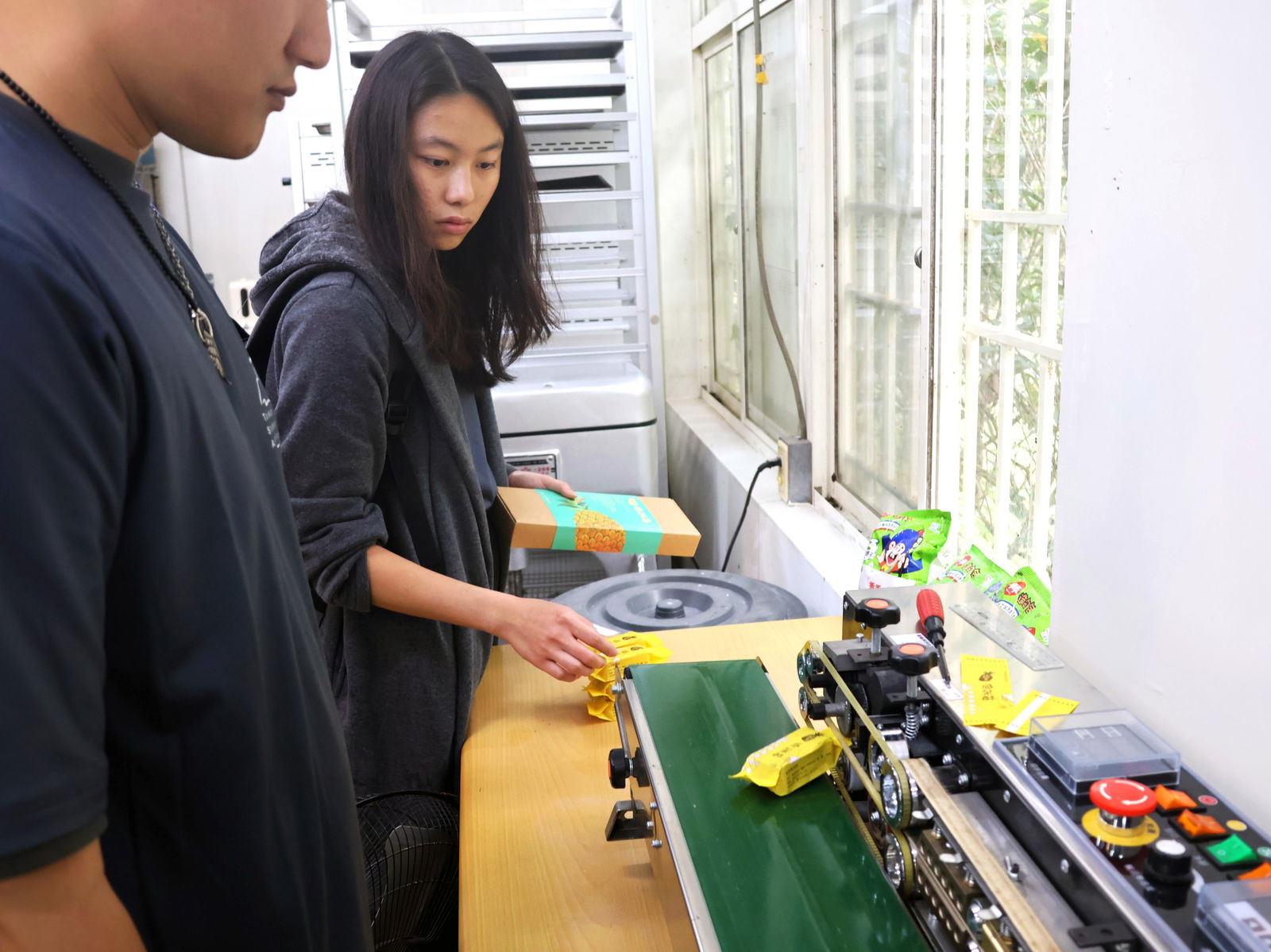 Laura Chen, a graduate student in UOG’s SAFNR program, runs her custom-made pineapple cakes through a packaging machine at the Mingquan Ecological Leisure Farm, an agritourism business in Pingtung County, Taiwan.