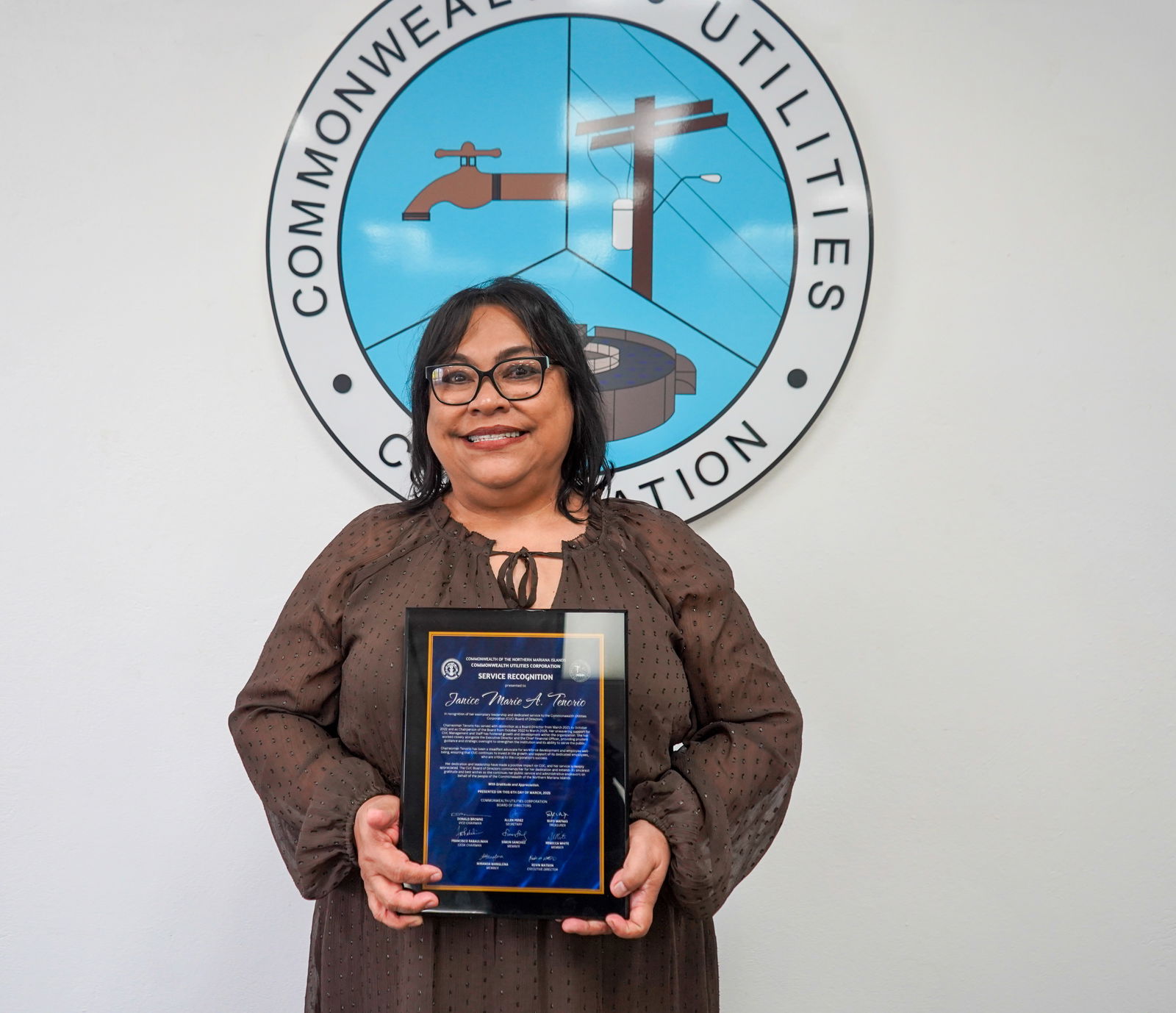Janice Tenorio holds a plaque of appreciation from the CUC board of directors and management.CUC photo