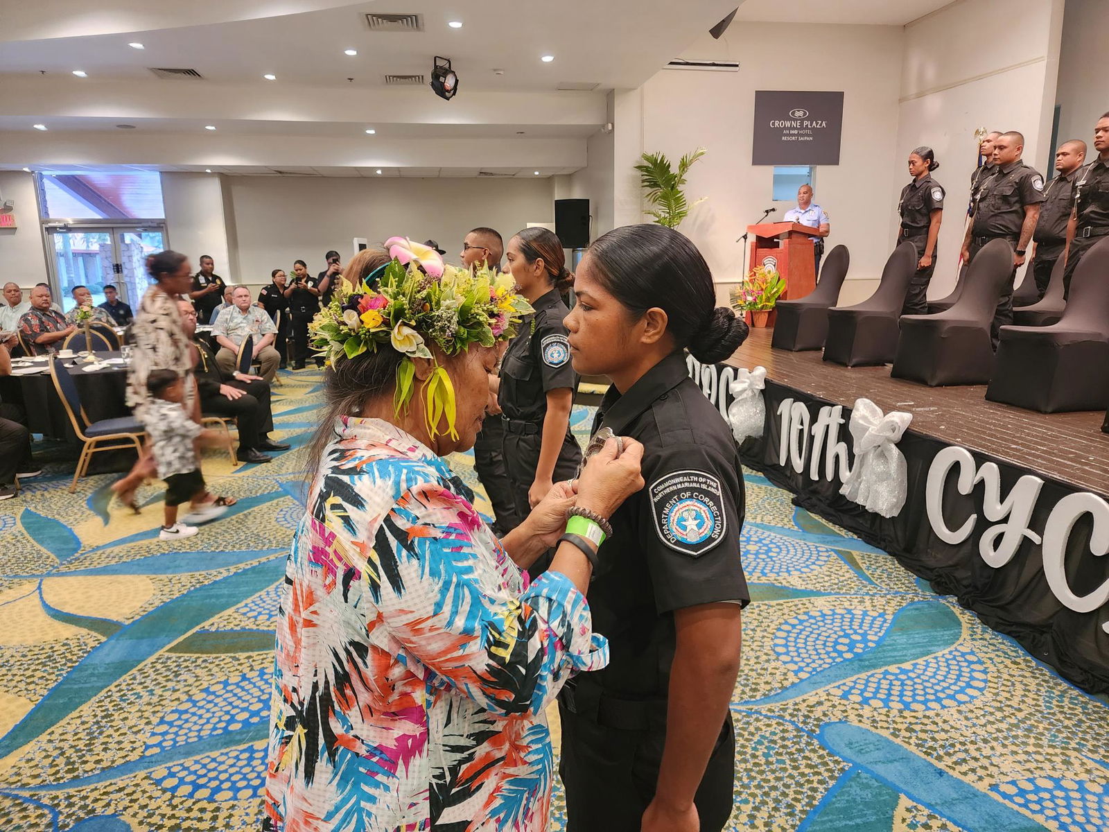 Bridgett Kapileo pins the Corrections badge on her daughter, CO1 Crystal I. Kapileo.