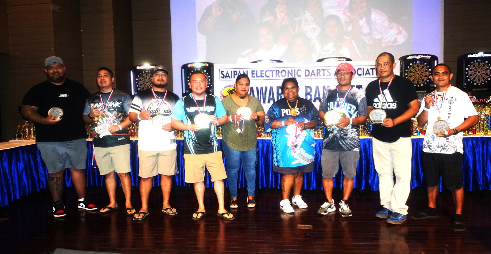 The MVPs of each division pose for a photo with their trophies during the awards banquet of the 2024 SEDA Bud Light Dart League at the Taga Hall of Saipan World Resort on Saturday.