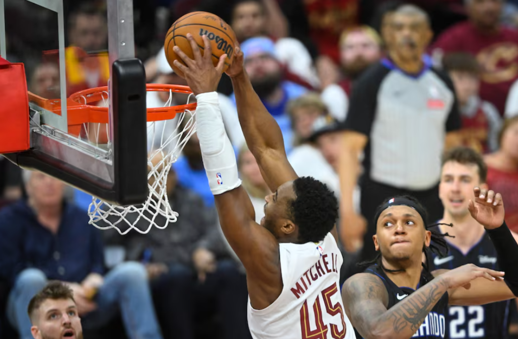 Cleveland Cavaliers guard Donovan Mitchell (45) dunks beside Orlando Magic forward Paolo Banchero (5) in the fourth quarter at Rocket Arena in Cleveland, Ohio, March 16, 2025.Photo by David Richard/Imagn Images