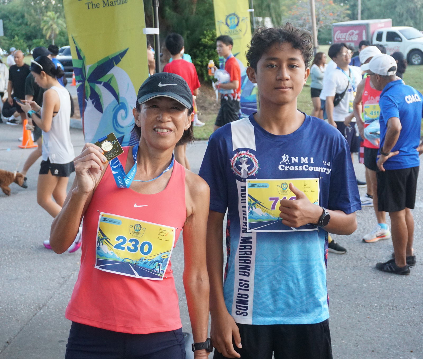 Noriko and Takeru Jim pose for a photo while holding their gold medals in the half marathon and 5km events of the Skechers Saipan Marathon 2025 at Micro Beach on Saturday morning