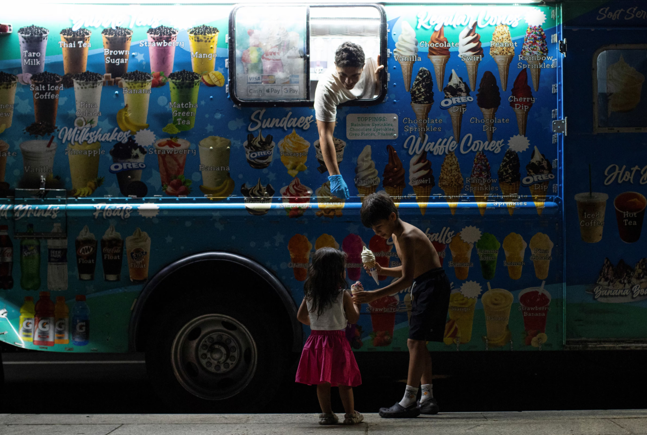 Children hold ice cream near a food truck vendor at the National Mall in Washington, D.C., Aug. 12, 2024.