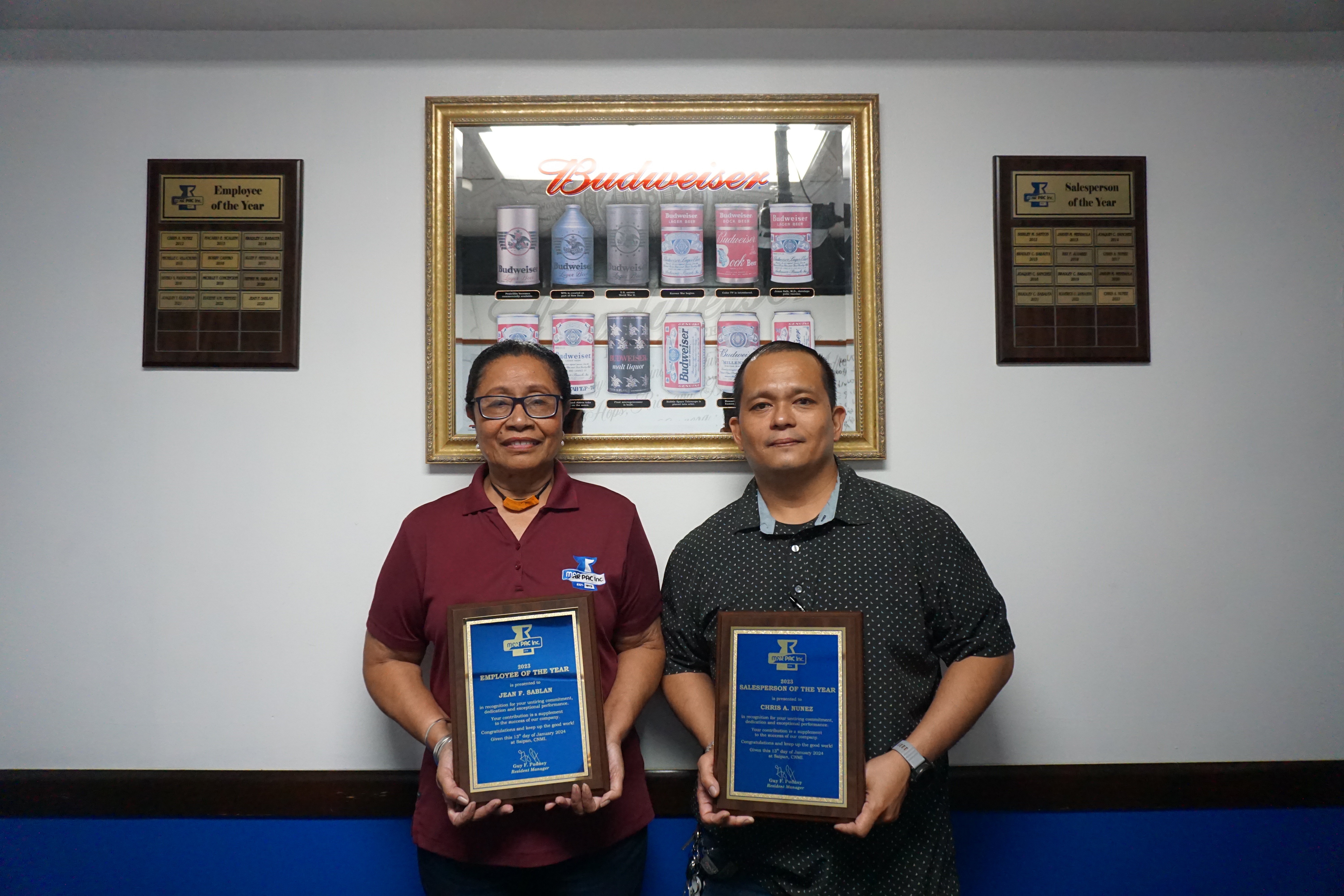 Jean Sablan, poses with the plaque she received for winning MarPac's 2023 Employee of the Year award. She is photographed next to Saleman of the Year Chris Nunez.