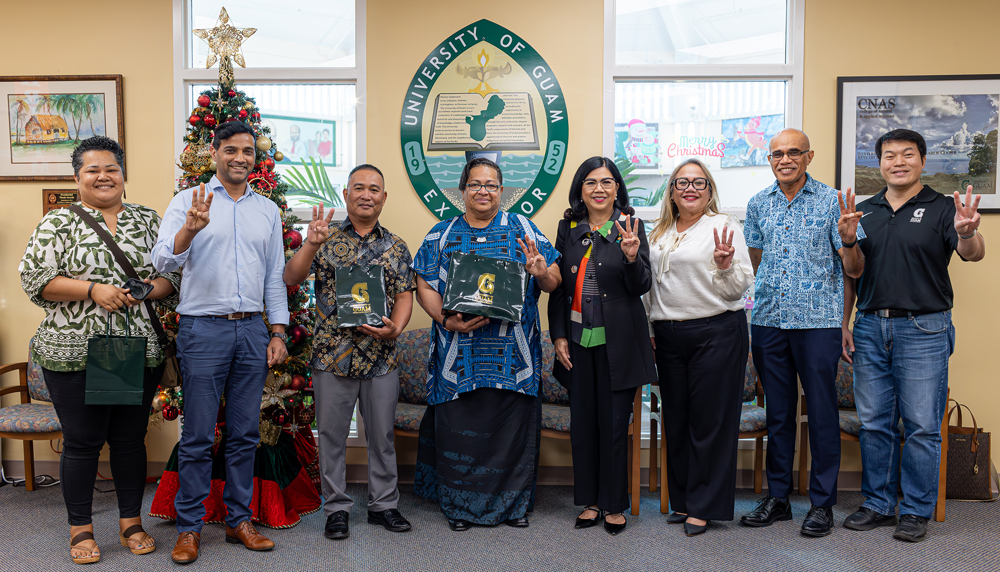 Administrators and faculty from the College of Micronesia-FSM and the University of Guam display the UOG trident symbol on Dec. 10, 2024, following the signing of a 2+2 transfer agreement between the two institutions for students studying agriculture.