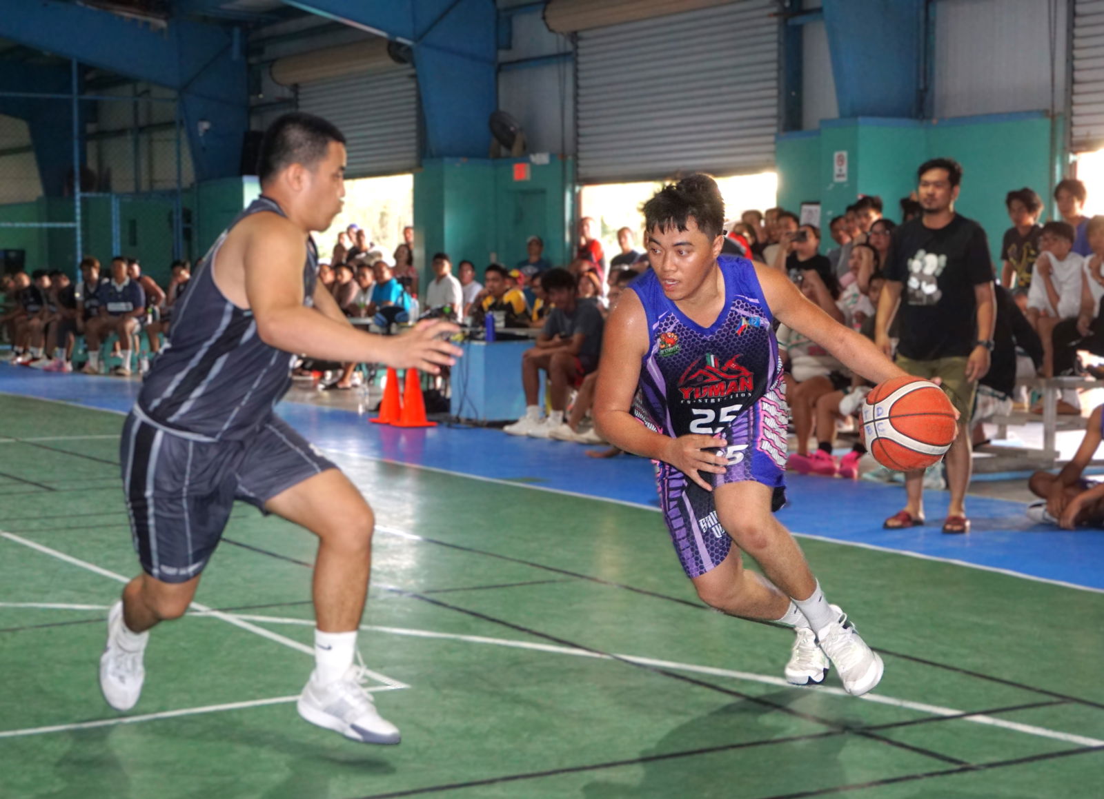 Yuman Construction's Justine Enano attempts to drive past a defender during a playoff game against Hoop Academy in the Alpha Kappa Rho 1st Semi-Open Invitational Basketball League 2025 at the TSL Sports Complex on Sunday.Photo by James F. Sablan Jr.