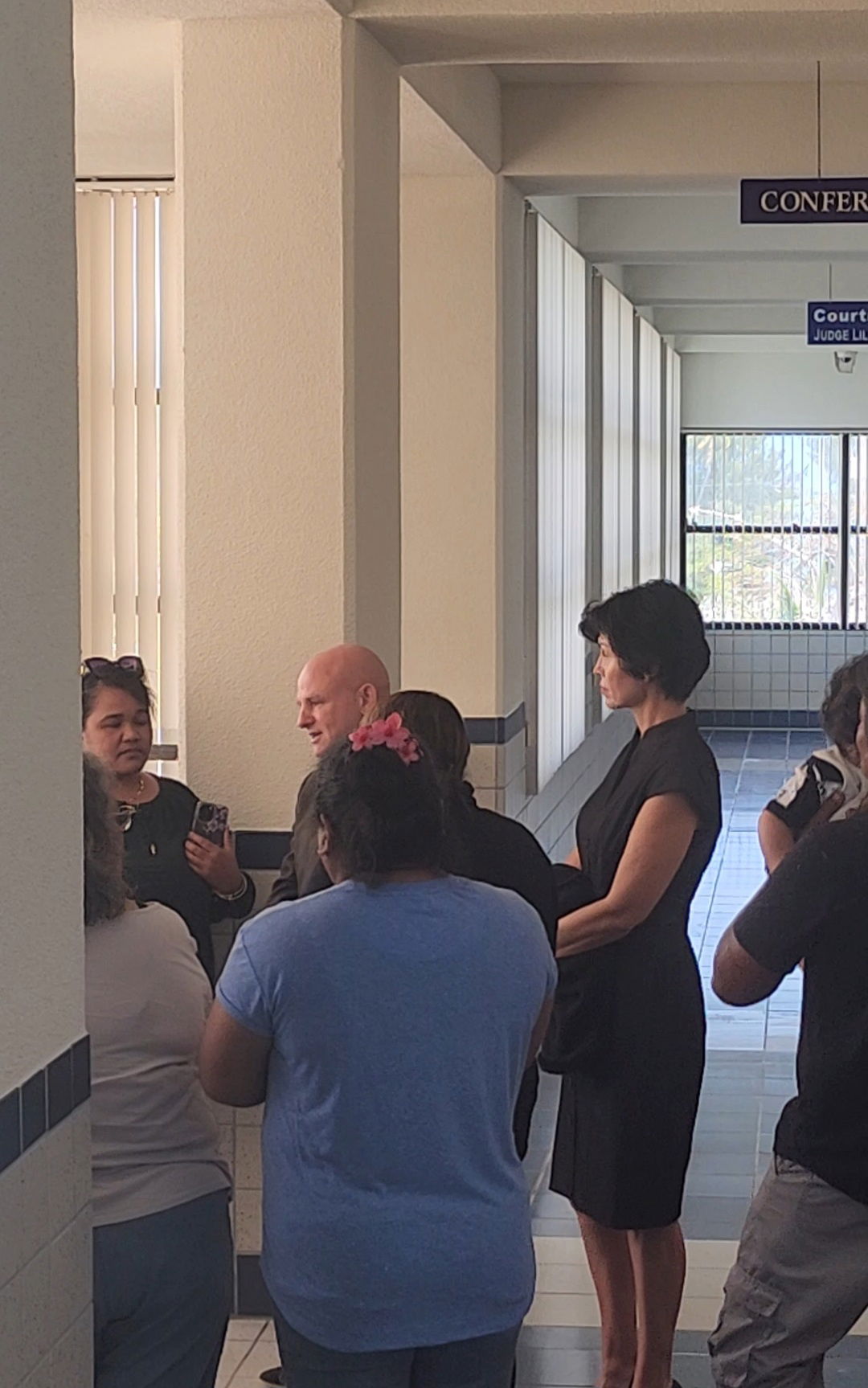 Attorney Joey McDoulett, who represents Calvin Tagabuel, speaks to his client's family members after a hearing on Monday.