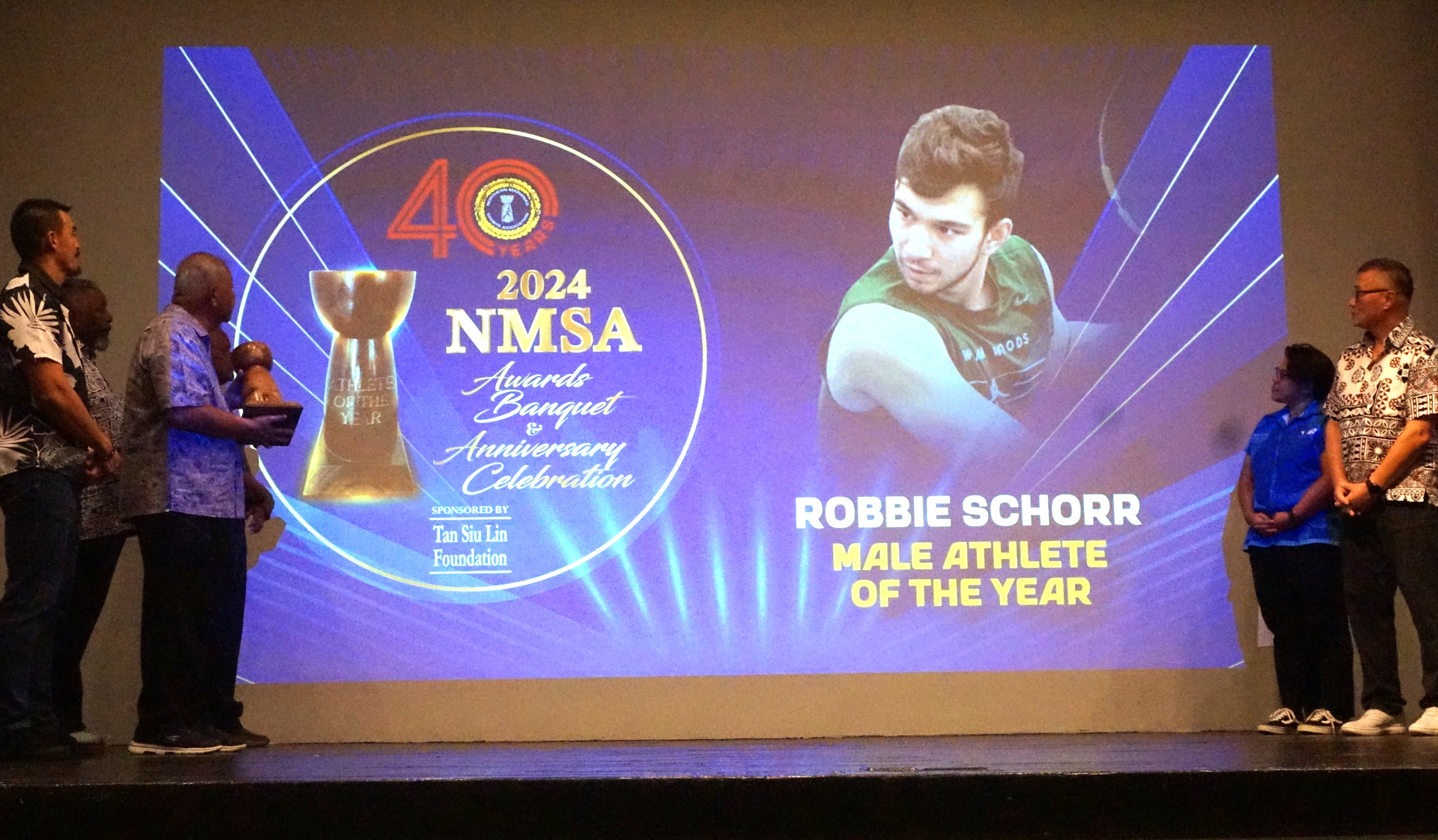 NMSA officials look at the photo of Robbie Schorr, the Male Athlete of the Year, during the Northern Marianas Sports Association annual awards banquet and 40th anniversary celebration at the Taga Hall of Crowne Plaza Resort Saipan on Thursday.Photo by James F. Sablan Jr.