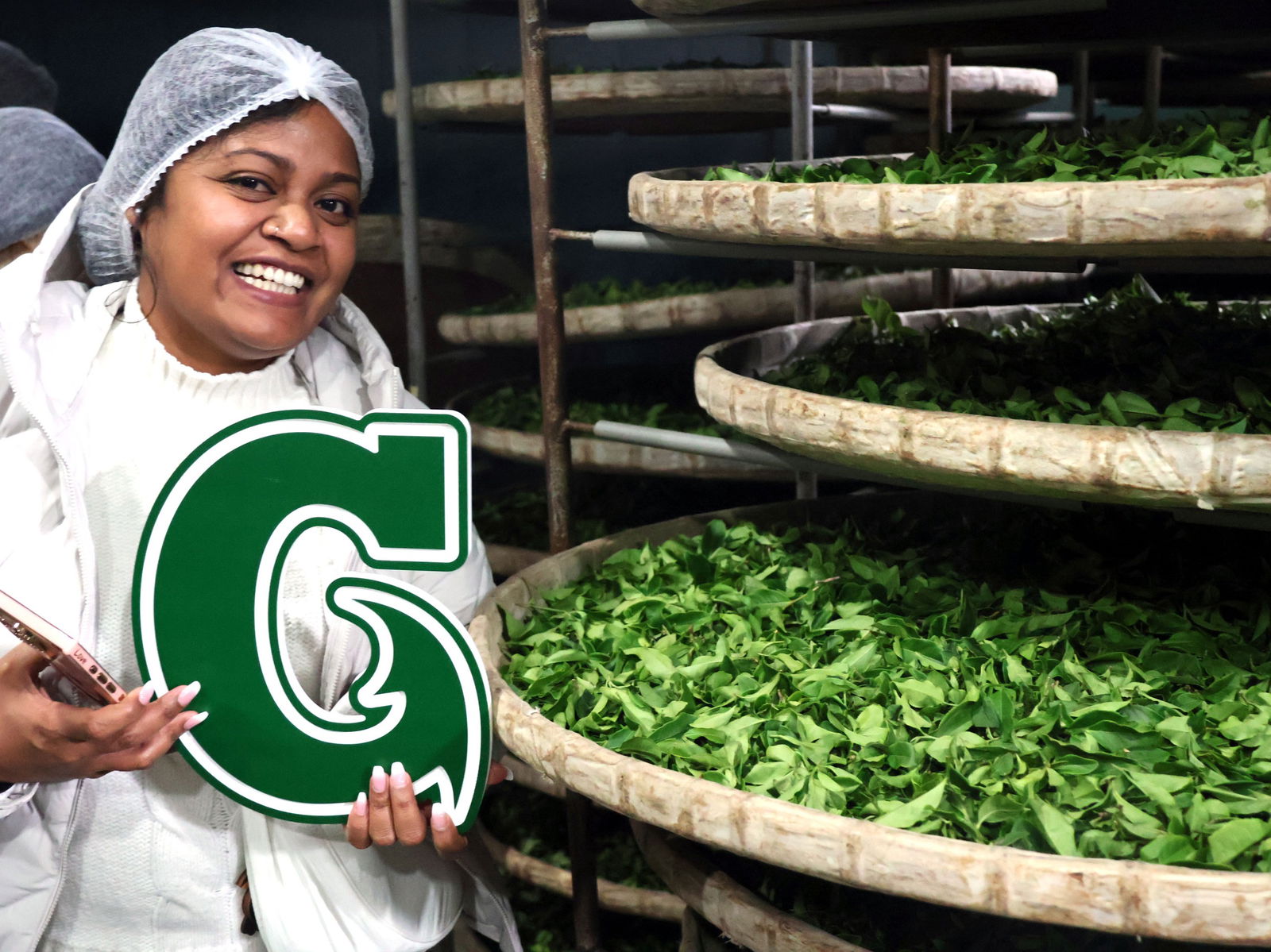 Business major Keana Mesubed holds the University of Guam “Big G” on a tour of Tea & Magic Hand, an agritourism business in Taiwan.