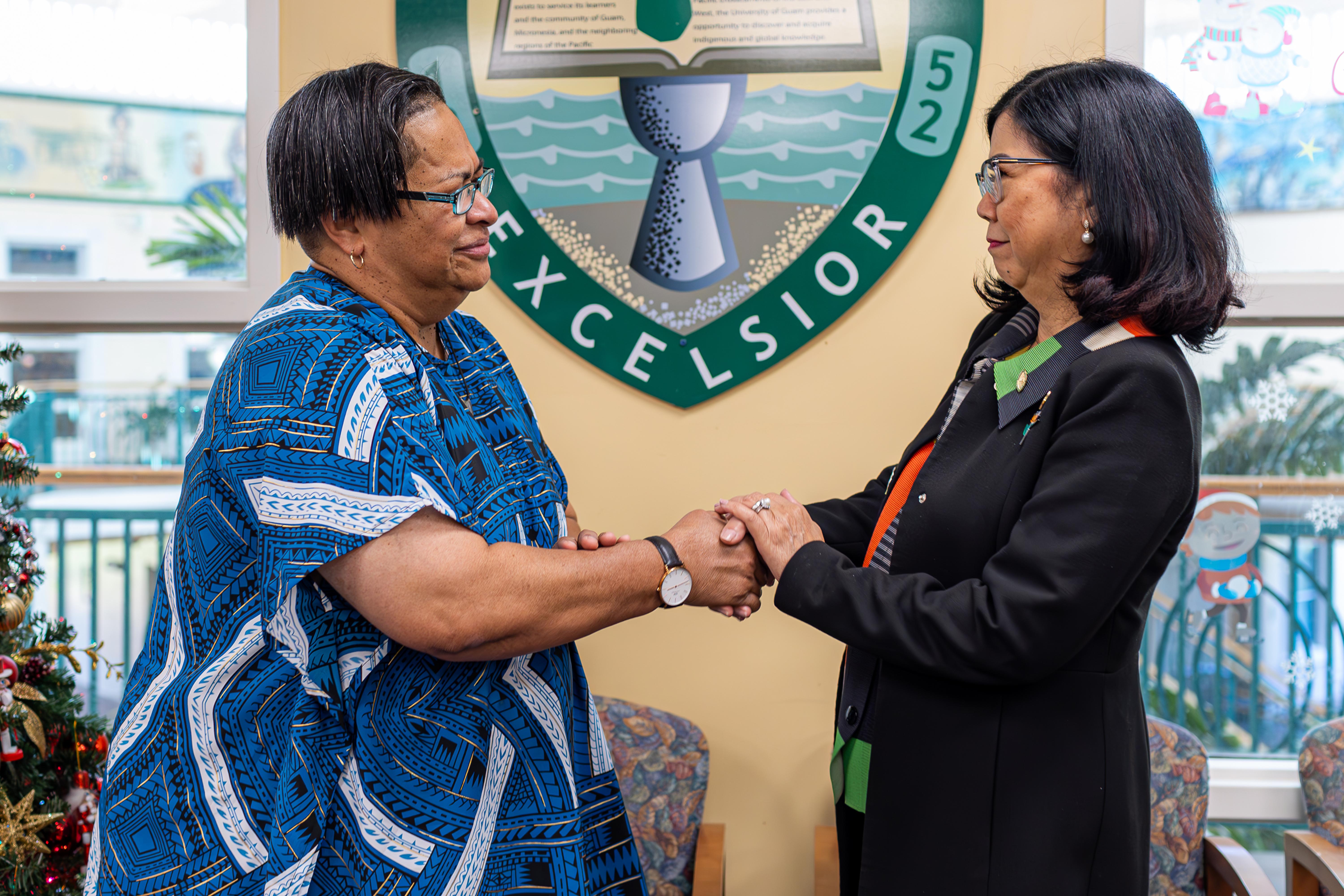 The president and CEO of the College of Micronesia-FSM, Theresa Koroivulaono, shakes hands with University of Guam President Anita Borja Enriquez on Dec. 10, 2024, following the signing of a 2+2 transfer agreement between the two institutions for students studying agriculture.