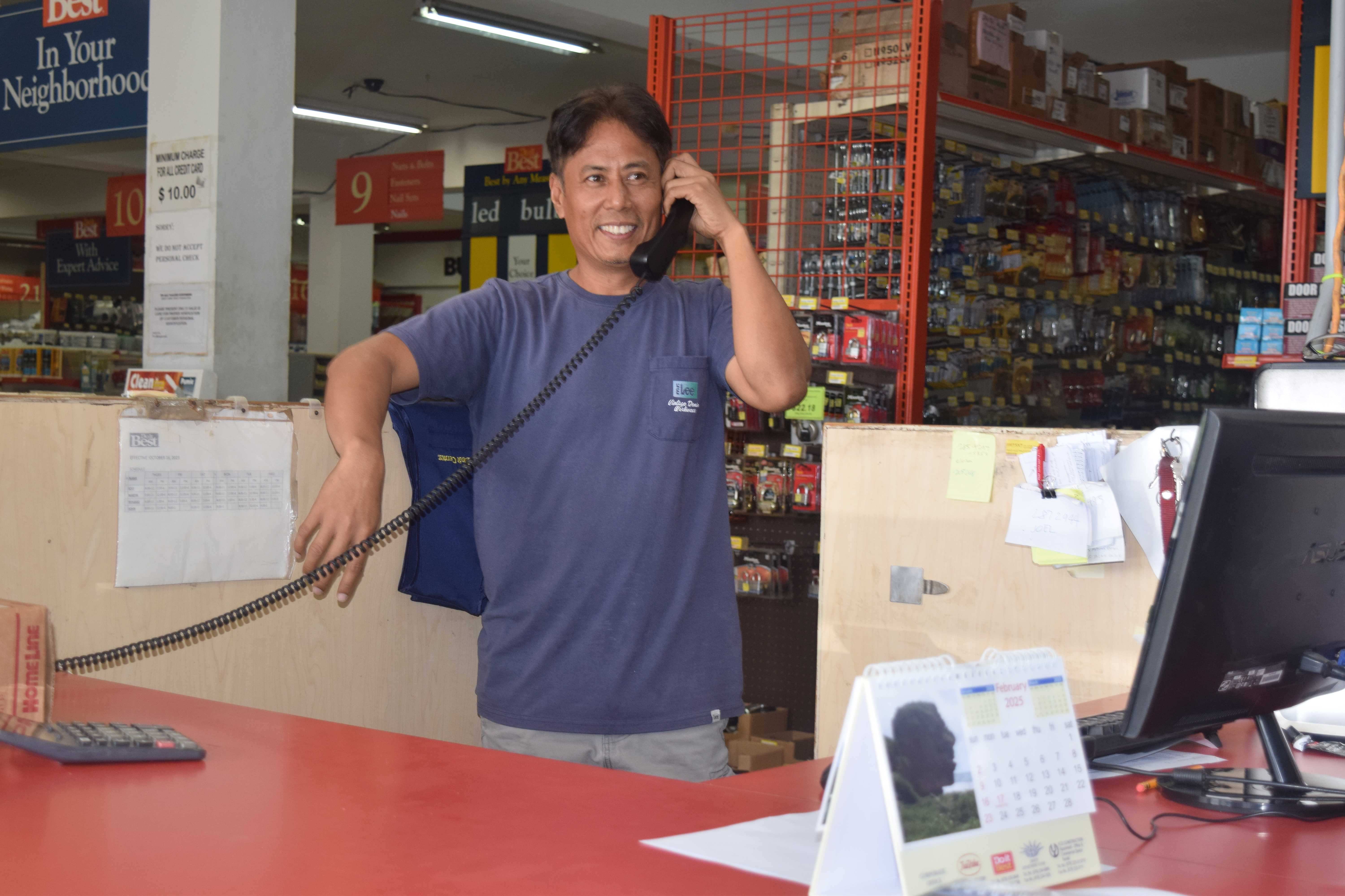 YCO Corporation Do It Best store supervisor Bernard Pamintuan receives a call from a customer. 