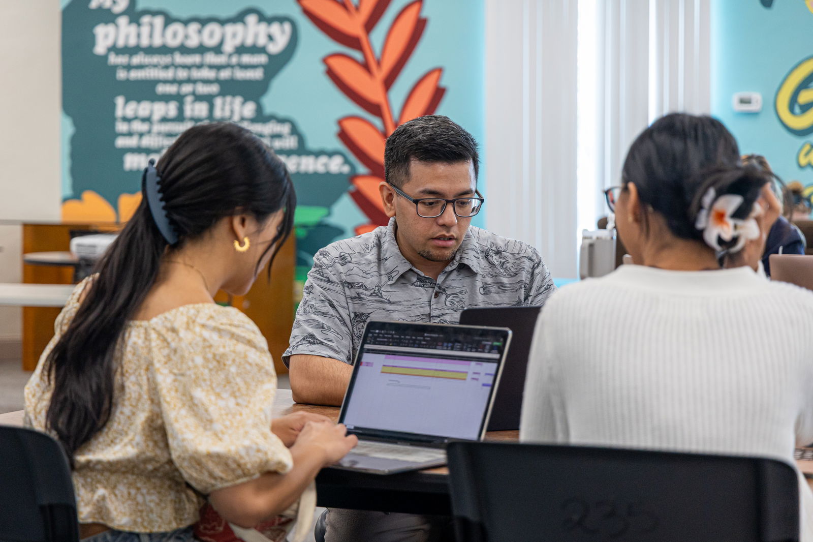 Jaran Aguon, center, academic advisement and assessment coordinator for the School of Business and Public Administration, assists students at the Triton One Stop on the UOG campus. The Triton One Stop is open from 9 a.m. to 2 p.m., every Tuesday in April to assist students with academic advisement, financial aid, registration, and other student services.UOG photo