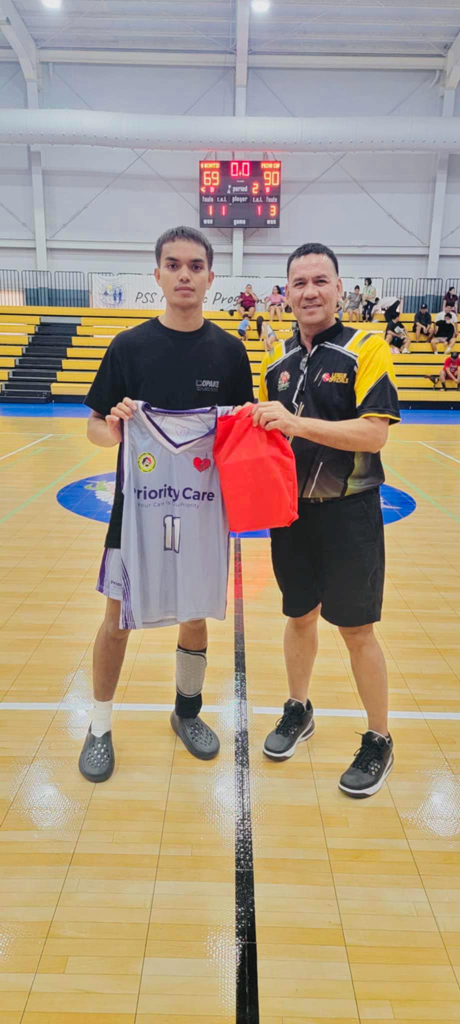 Priority Care’s Chioni Dela Cruz receives the Best Deal Best Player of the Game award from League Commissioner Bernie Abuen after beating A+ Consulting in the open division.Contributed photo 