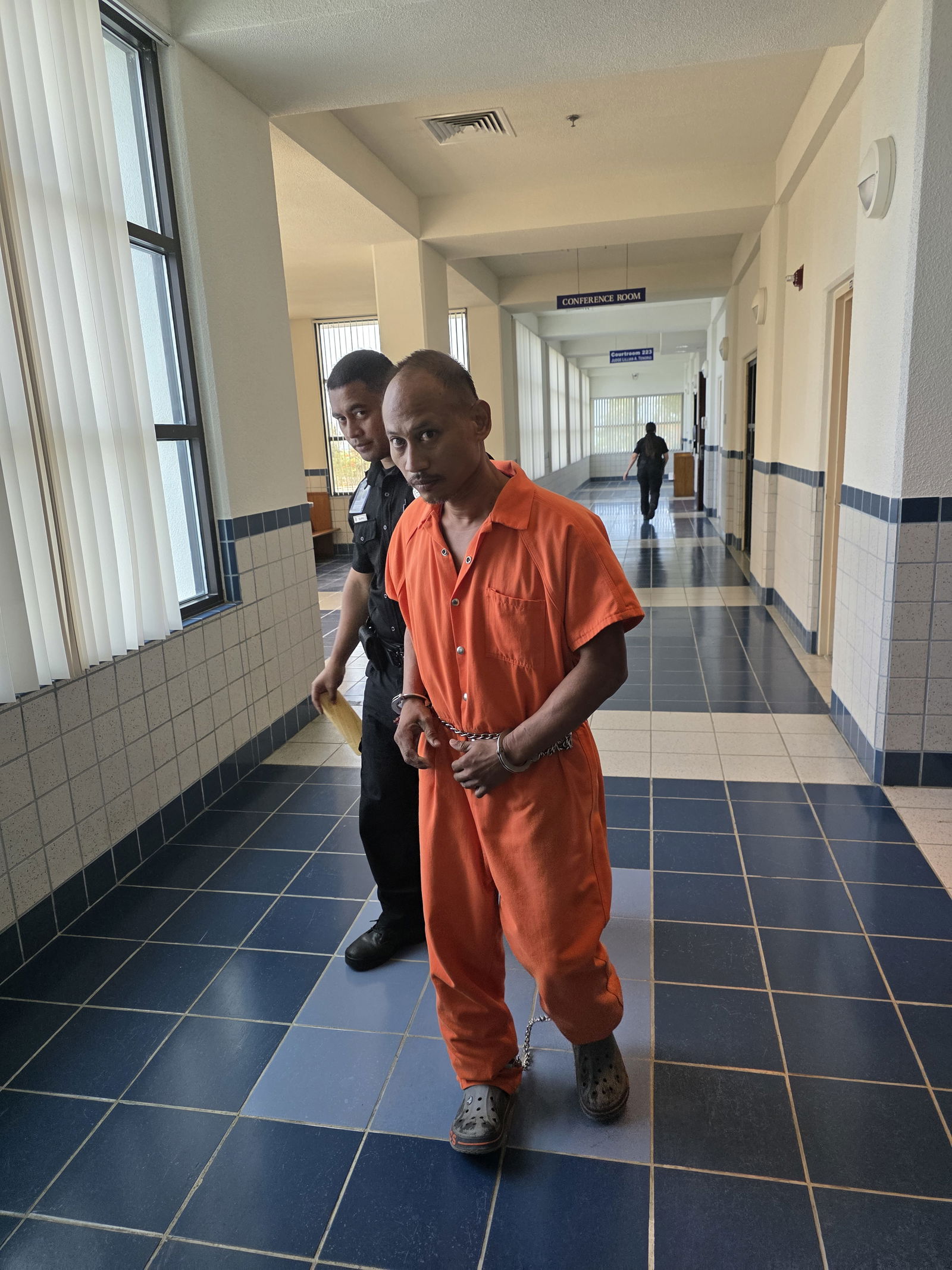 Jerome Deleon Guerrero, also known as William Taitingfong, is escorted by a Corrections officer after a bail hearing at the local courthouse on Monday morning.