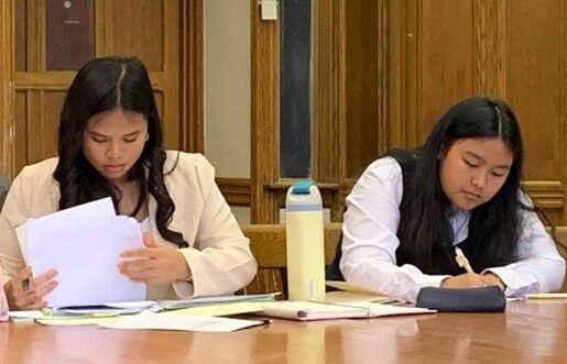 Jia Ross Nicdao and Julia Taitano review their notes for the first day of competition.