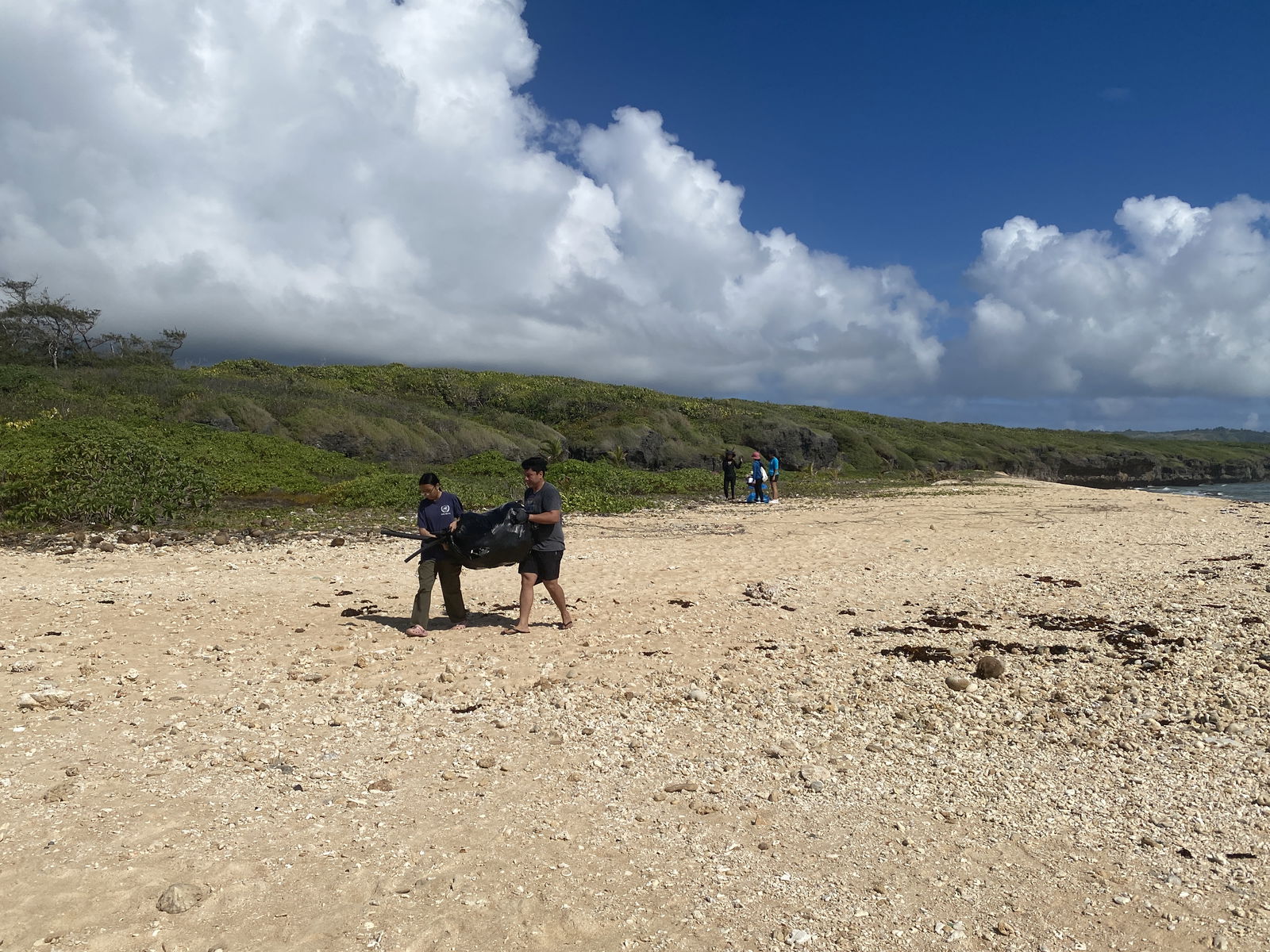 Volunteers haul out trash during the cleanup at Tank Beach on Sunday, April 13.