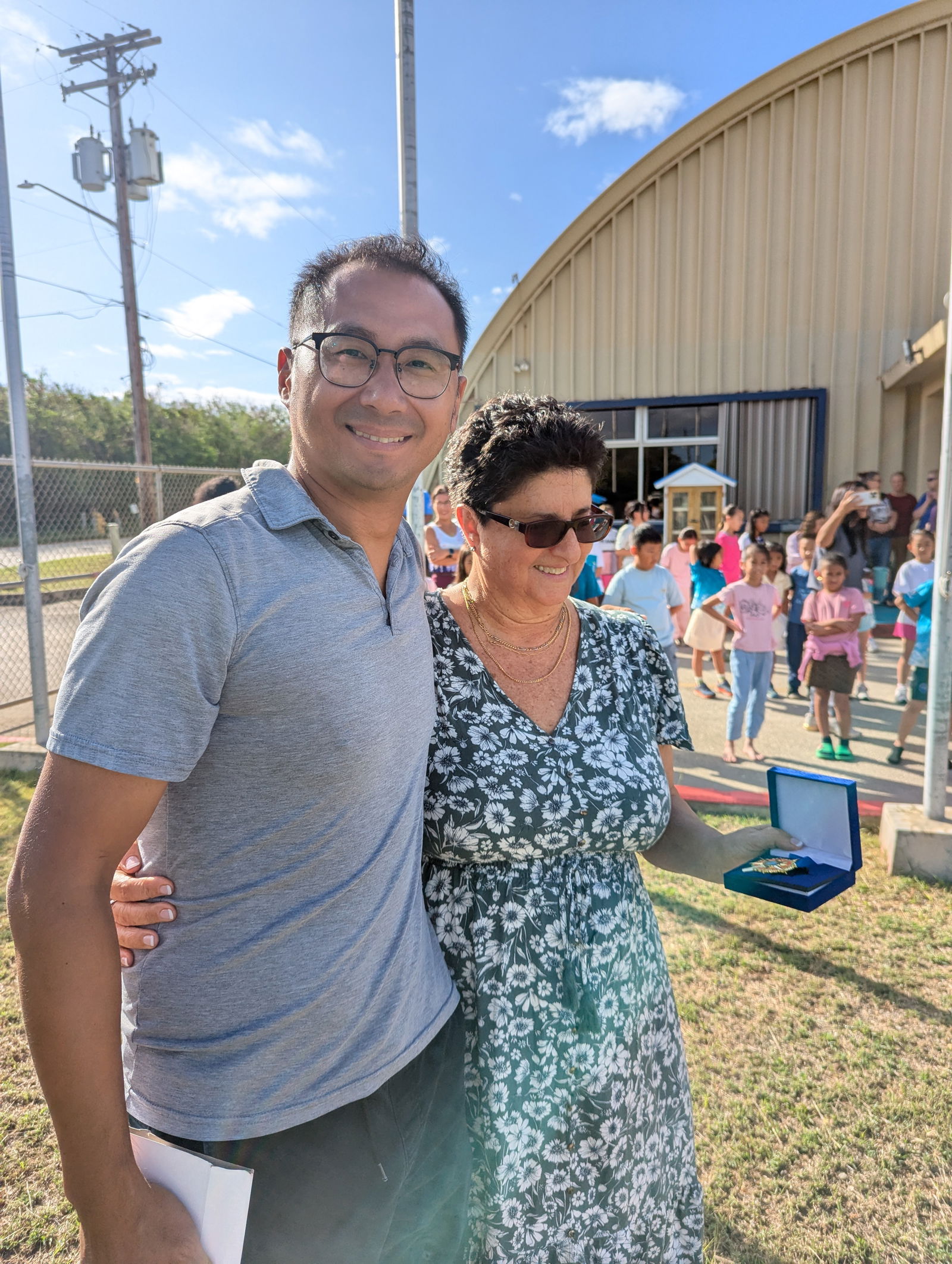 Ms. Mili shows her medal for outstanding service.