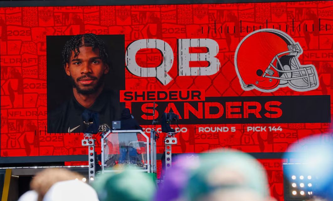 A graphic announcing Colorado quarterback Shedeur Sanders’ selection by the Cleveland Browns with the 144th overall pick is seen in the Draft Theater during the third day of the 2025 NFL Draft at Lambeau Field in Green Bay, April 25, 2025.Photo by Tork Mason/USA Today Network via Imagn Images