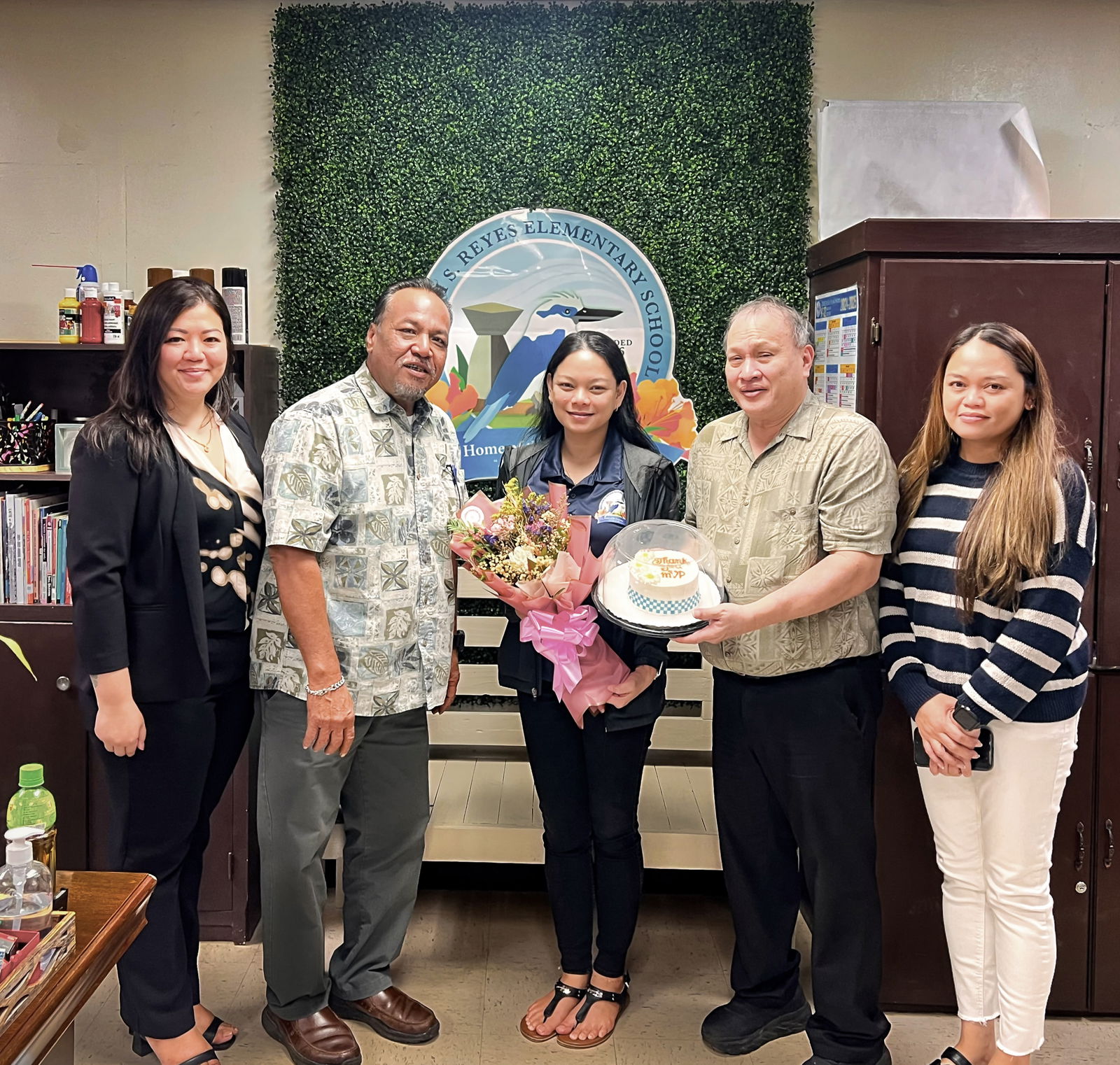 Dr. Jocelyn Manibusan, vice principal of William S. Reyes Elementary School, receives a bouquet of flowers and a miniature cake from Acting BOE Chairman Anthony L. Barcinas, BOE member Andrew L. Orsini, and Acting Commissioner of Education Jacqueline P. Che. Also in photo: Principal Dr. Lynn O. Mendiola.