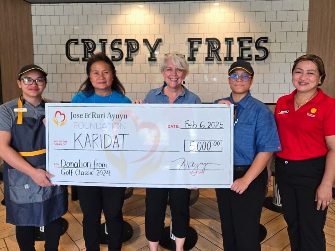 Marcia Ayuyu presents a check for $5,000 to Karidat Social Services on Feb. 6, 2025.