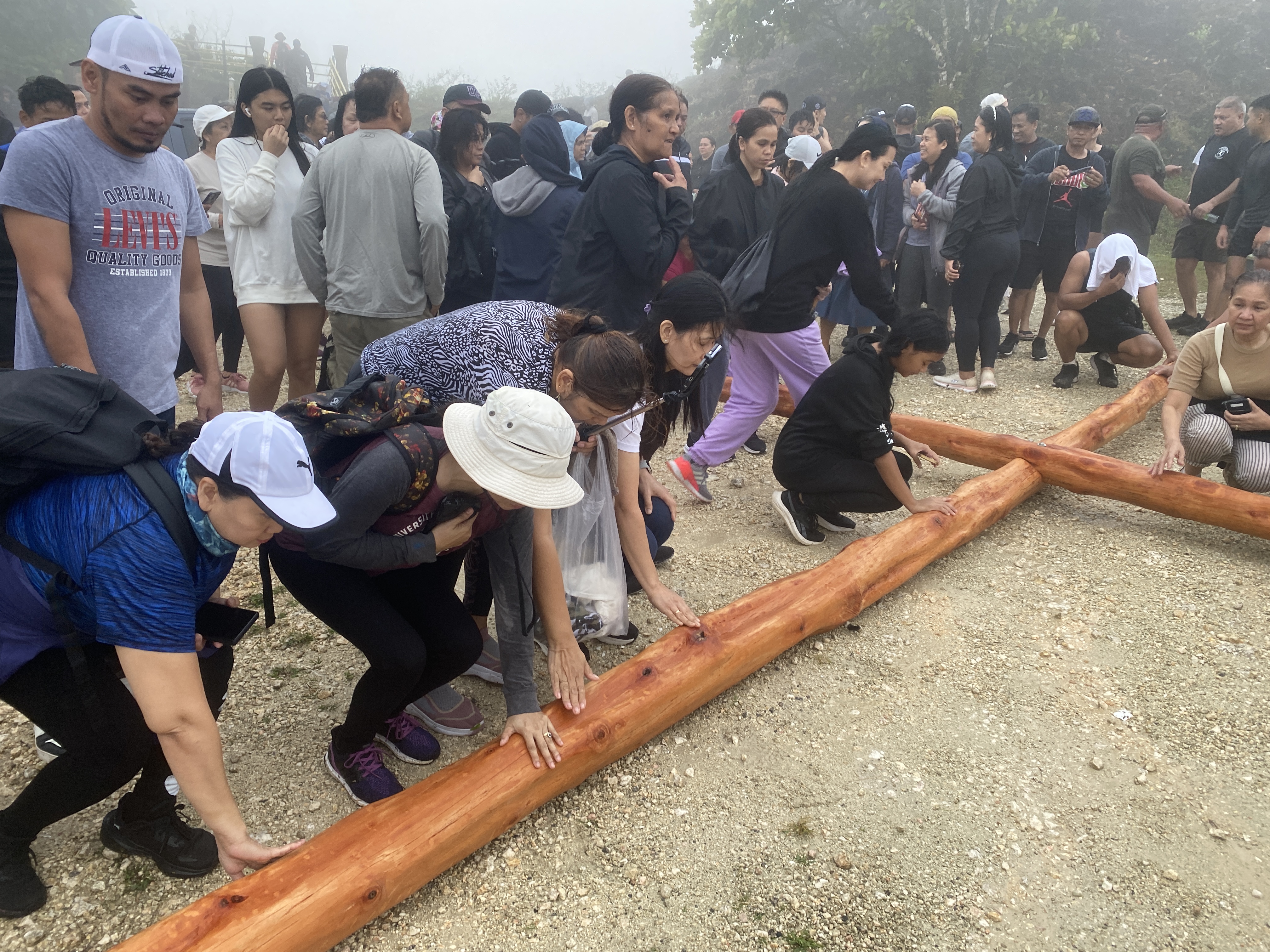 Devotees touched the wooden cross before it was lifted atop Mt. Tapochao’s summit.