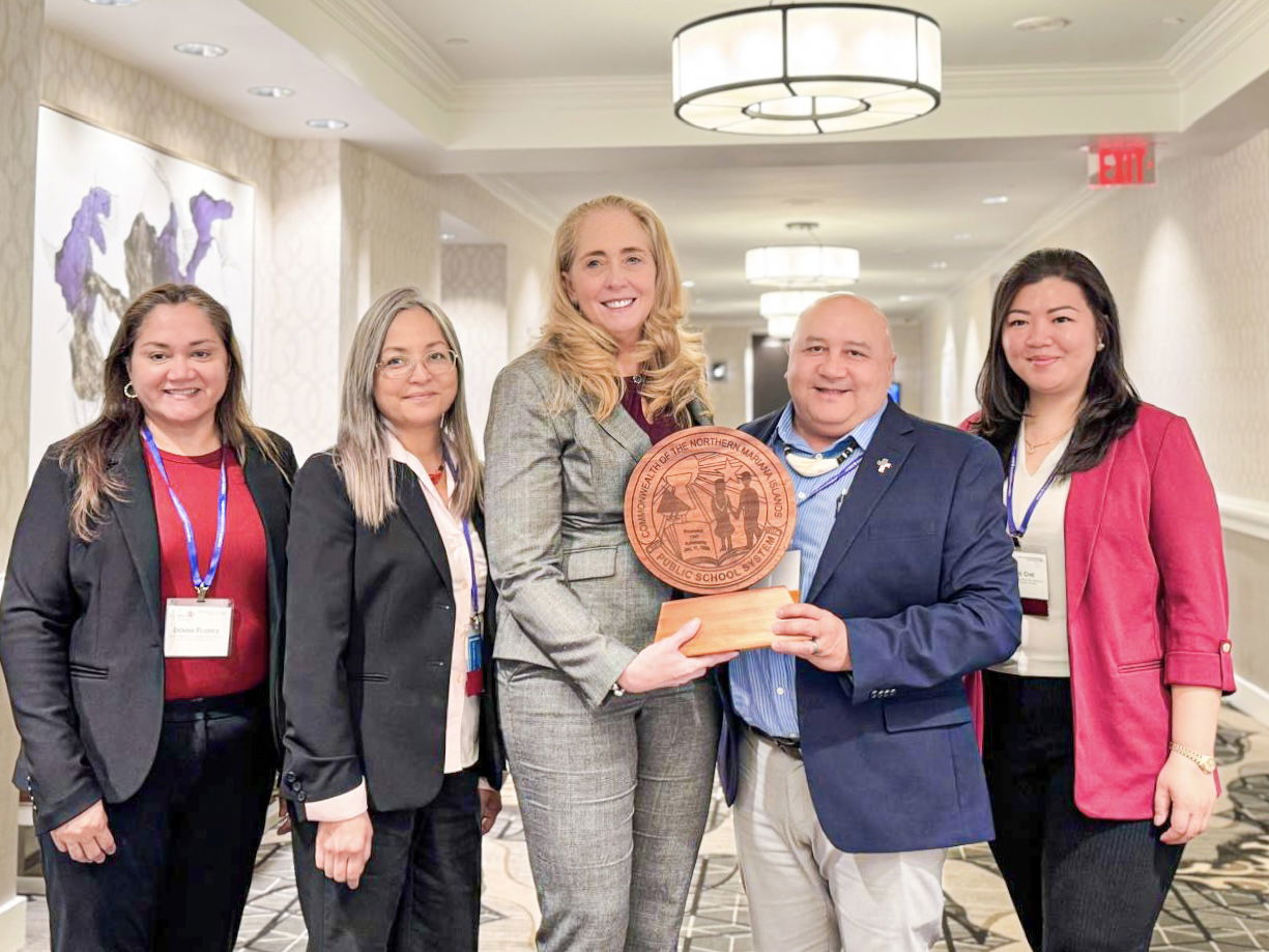 A friend and partner of PSS, Council of Chief State School Officers Chief Executive Officer Dr. Carissa Moffat Miller, center, receives a wood-carved logo of the CNMI Public School System from Commissioner of Education Dr. Lawrence F. Camacho. Also in photo are PSS Federal Programs Officer and Federal Liaison Jacqueline P. Che, Special Education Director Donna M. Flores and Teacher Representative Dr. Dora B. Miura.