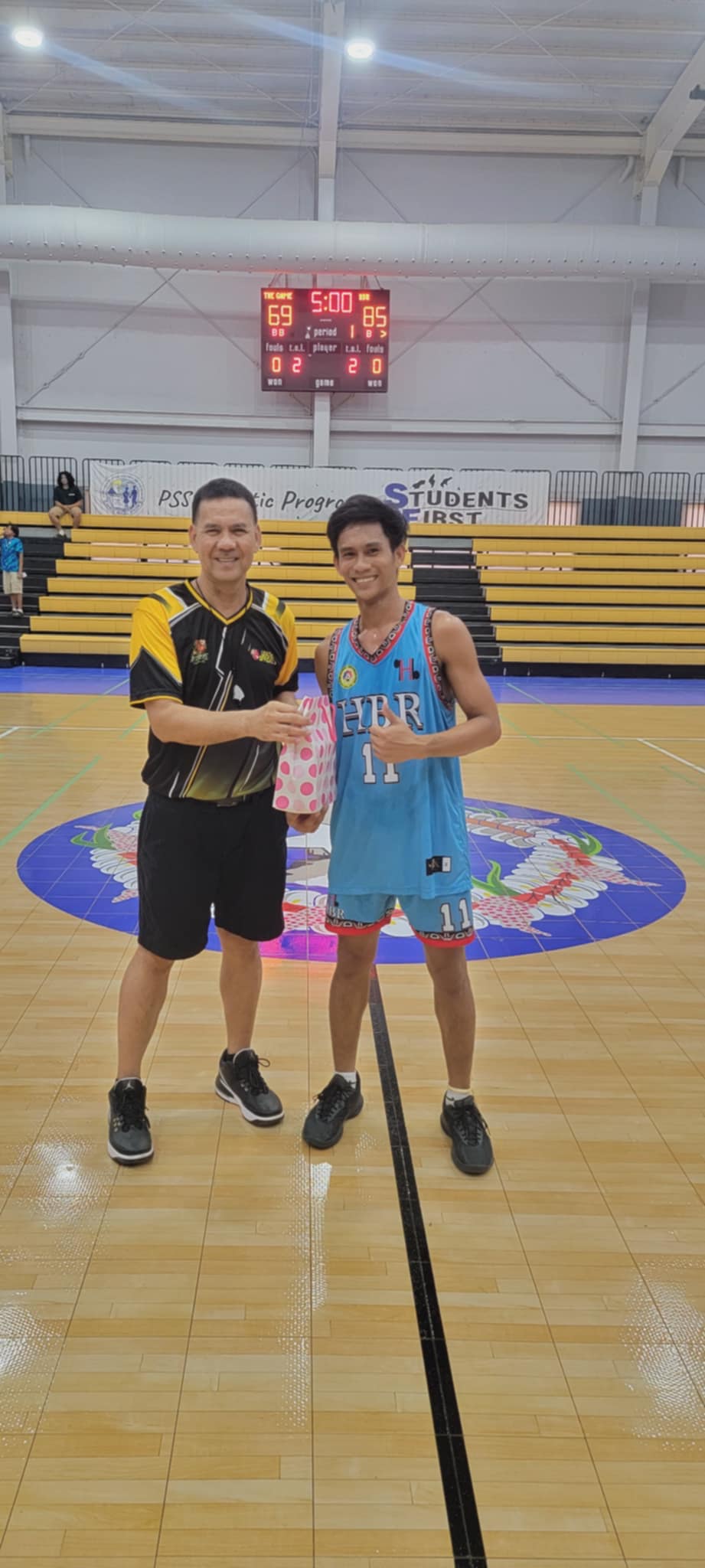 HBR Construction’s Jeff Victoria, right, the Best Player of the Game, receives a pack of butane gas sponsored by Best Deal from League Commissioner Bernie Ebuen at the Gilbert C. Ada Gymnasium on Sunday.Contributed photo