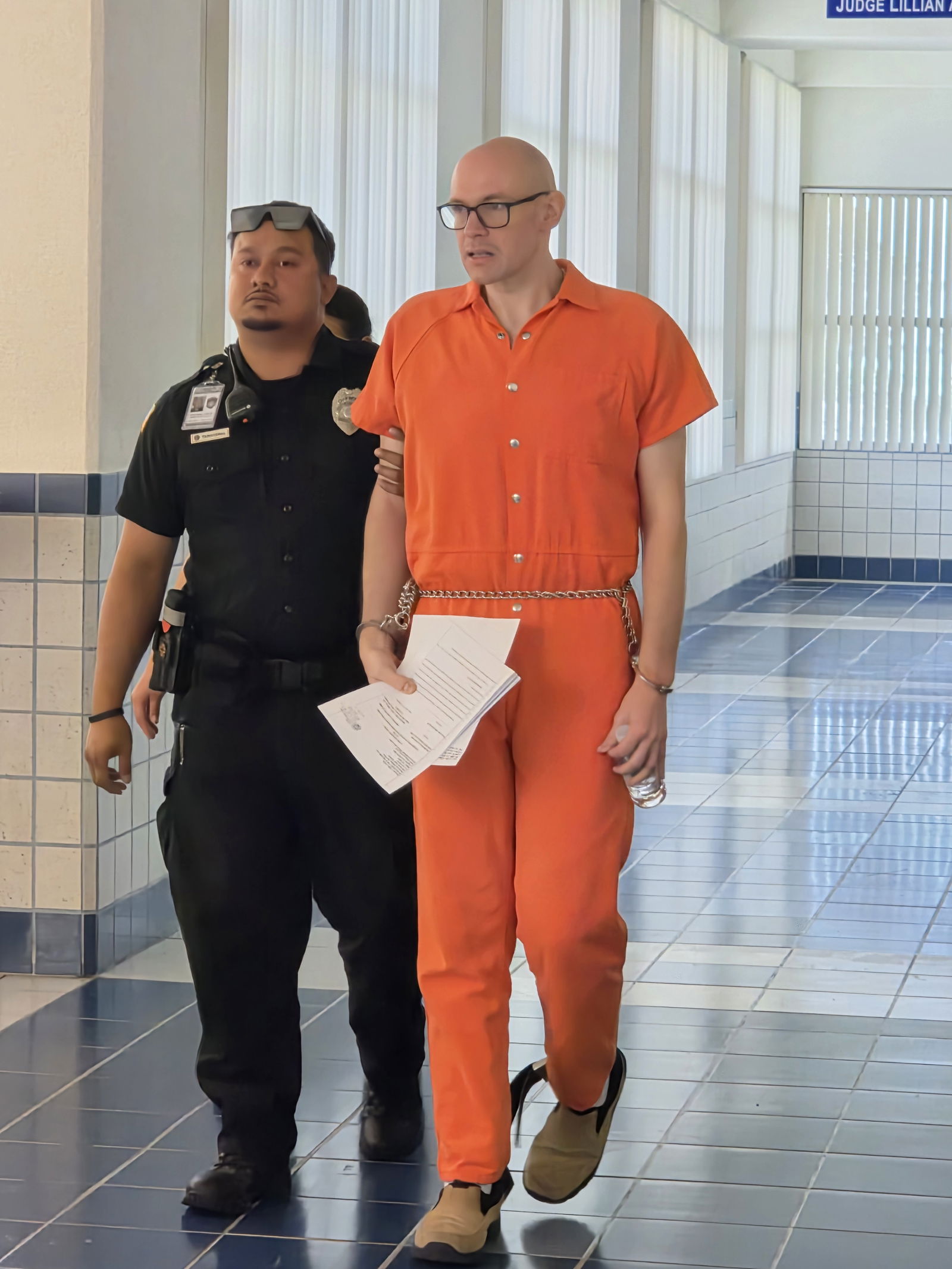 William Abraczinskas is escorted by a Corrections officer after a hearing on Monday morning.