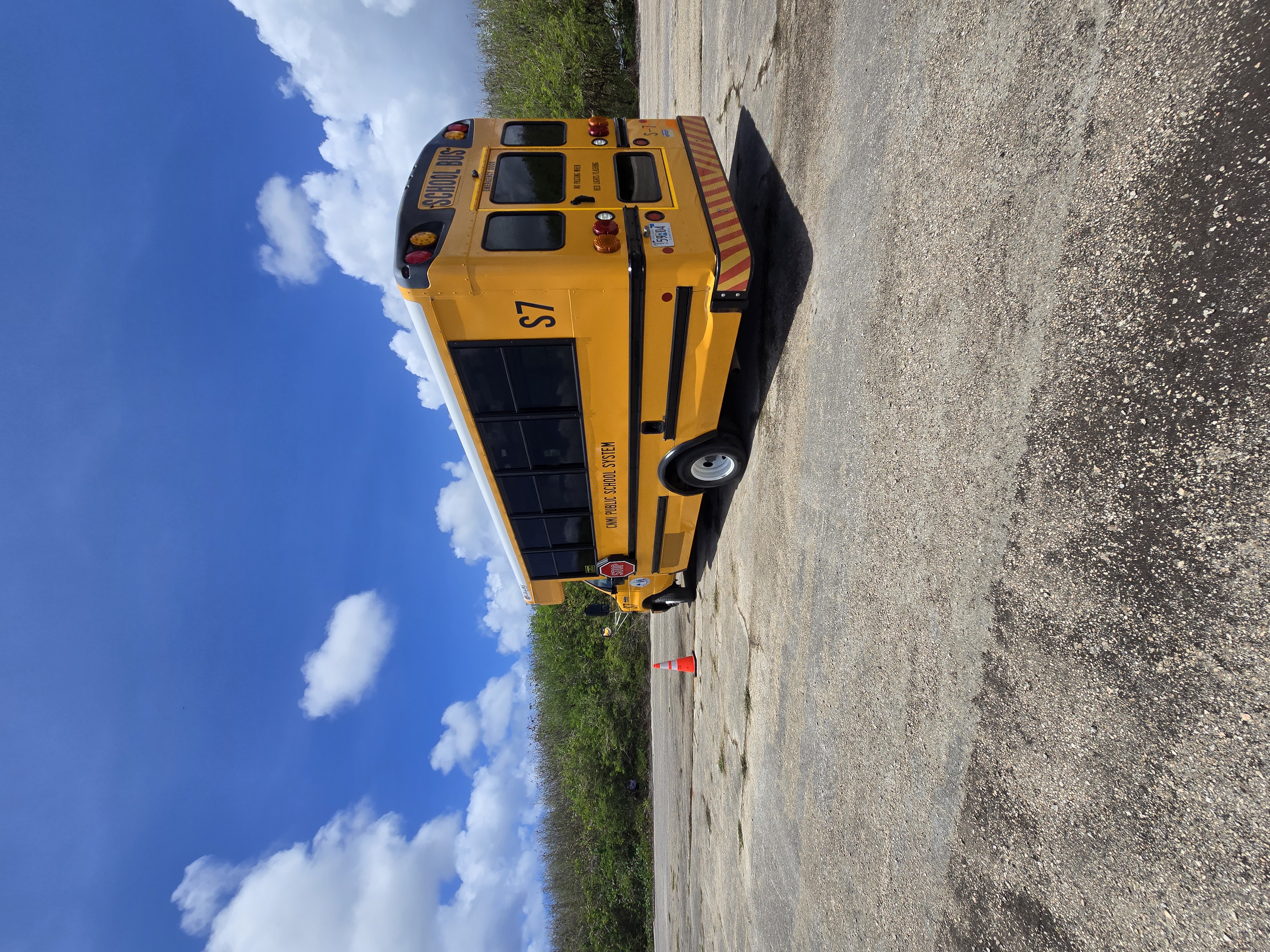 A driver of a Special Education school bus takes a U-turn around a coned-off spot.