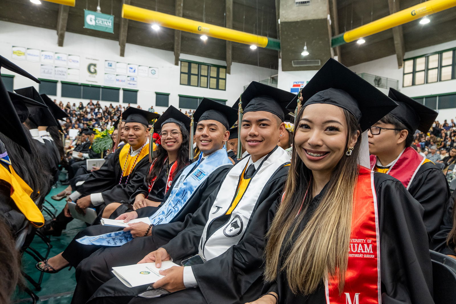 Graduates pose for a photo at the University of Guam Fanuchånan (Fall) 2024 Commencement Ceremony last December at the UOG Calvo Field House. UOG photo