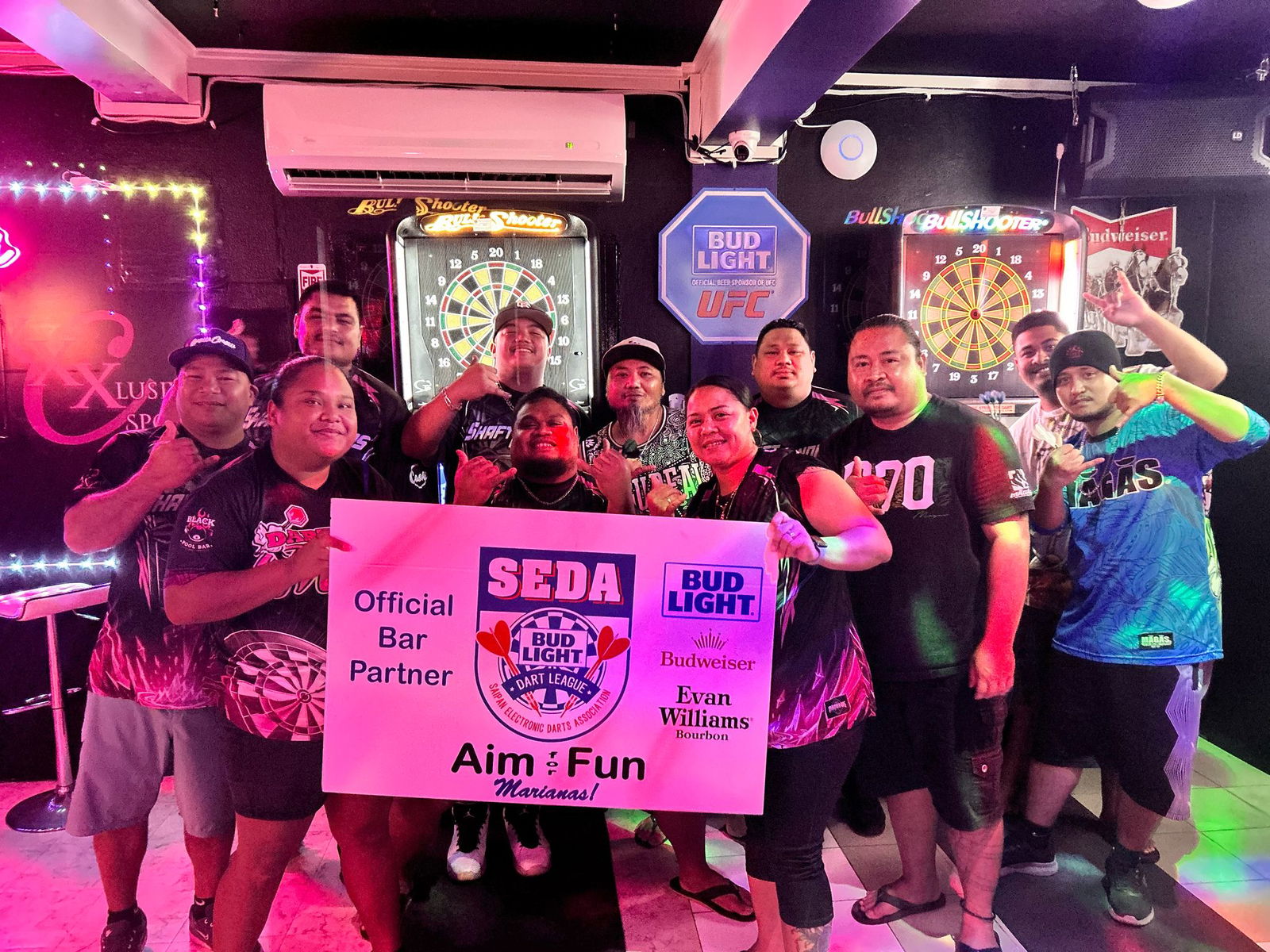 XXX Shaft Benders and Tom Yum Darting Dinanchi players pose for a group photo after Wednesday night's game in the Kingfisher C Division of the 2025 SEDA Bud Light Dart League at XXXclusive Spot.Contributed photo