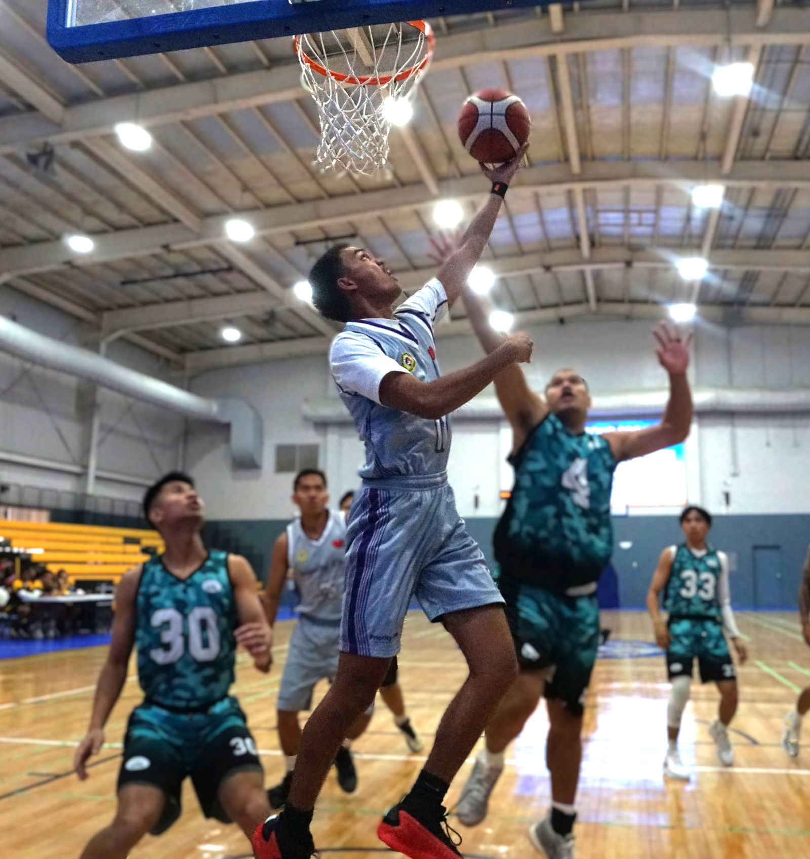 Priority Care's Chioni Dela Cruz finishes the reverse layup during a semifinal game against A+ Consulting in the Open Division of the 2025 IT&E United Filipino Organization Basketball League at the Ada gym on Sunday.Photo by James F. Sablan Jr.