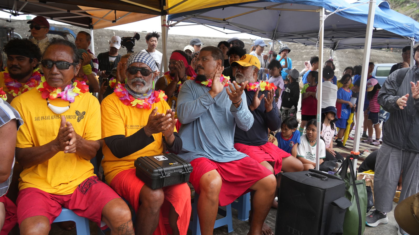 Members of the Alingano  Maisu applaud during a welcoming ceremony.